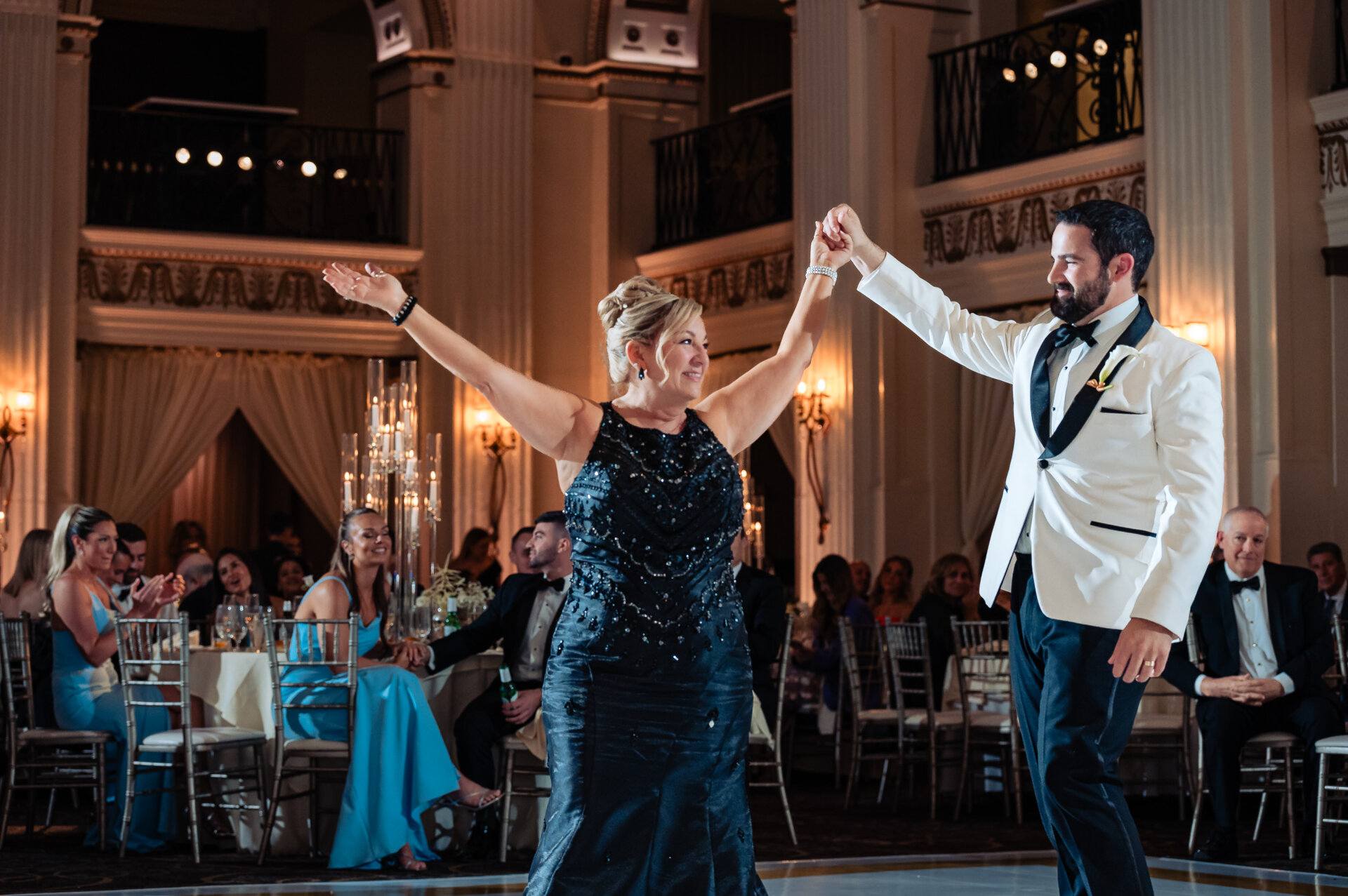Groom dances with his mother at the center of the ballroom floor during the wedding reception at The Ben.