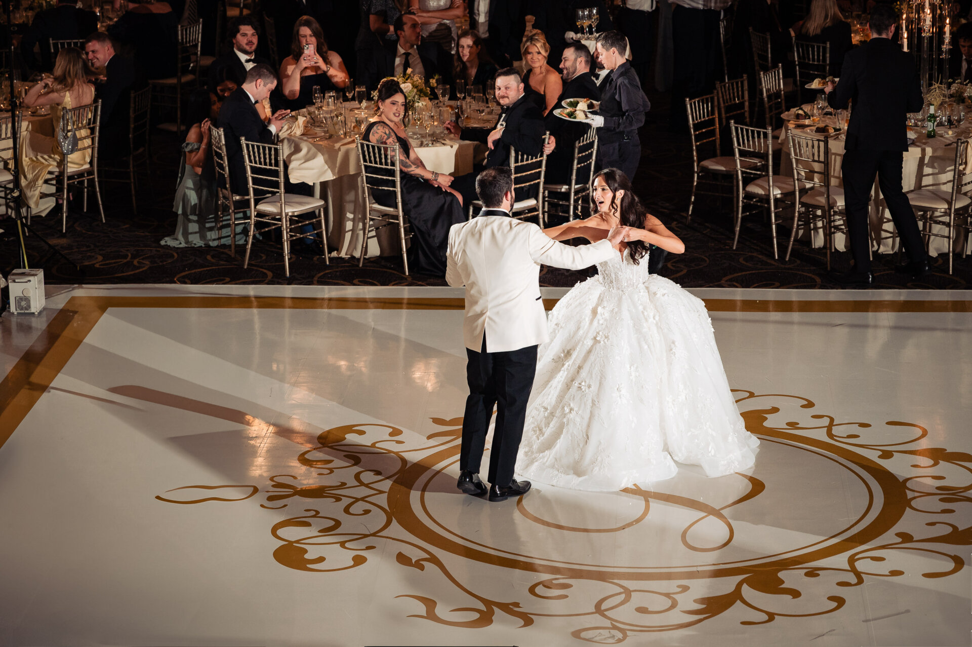 Bride and groom dance together at the center of the ballroom floor at The Ben wedding venue.