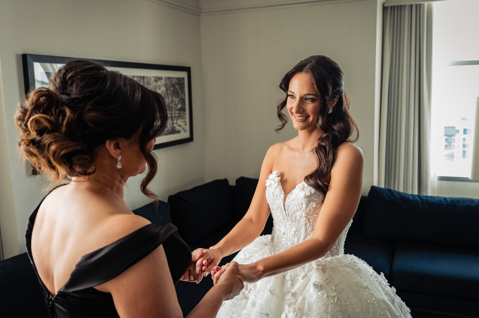 Mother and bride clasping hands, sharing an emotional moment before the ceremony