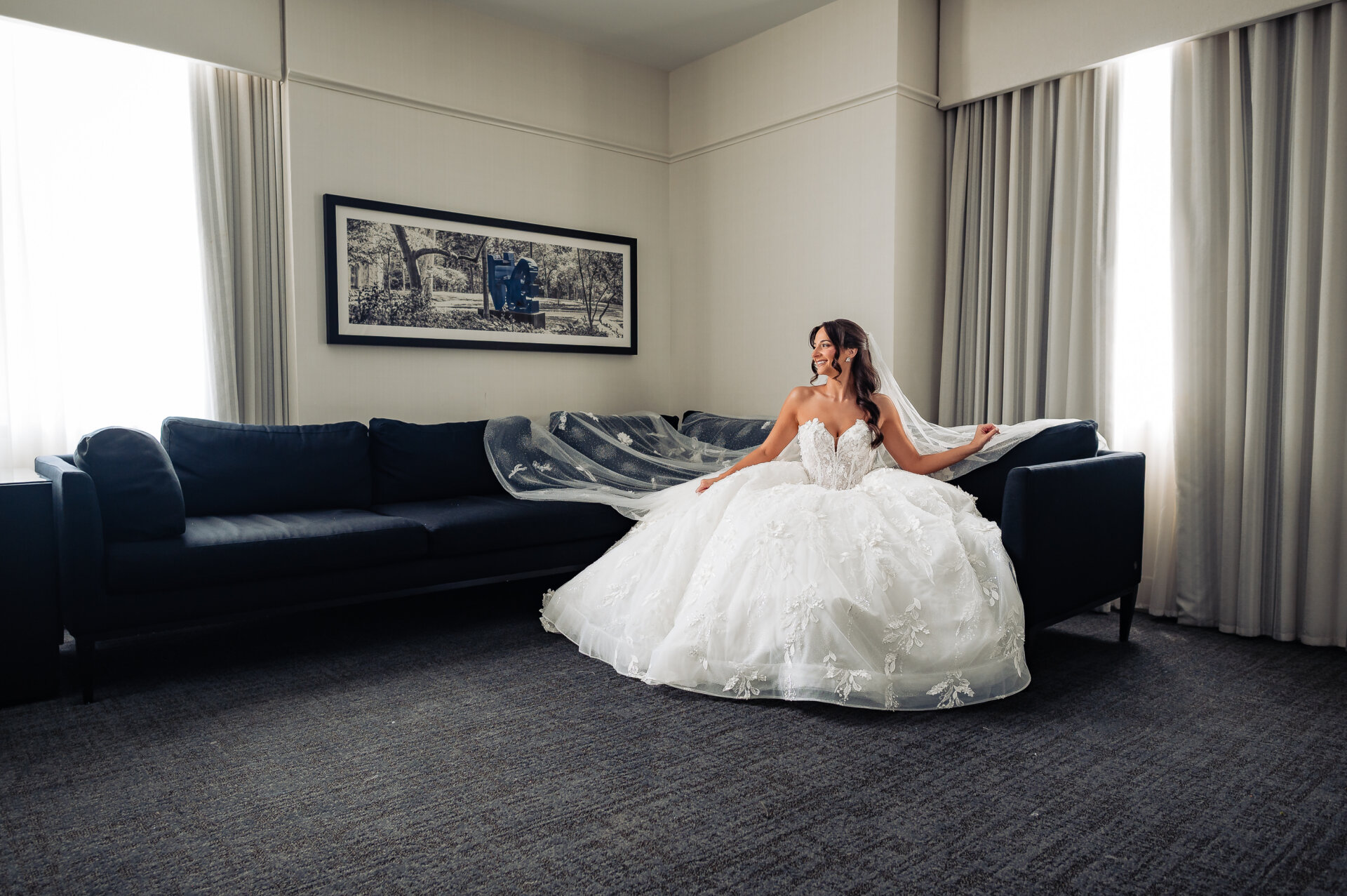 Woman in her wedding gown seated on a couch for a pre-ceremony portrait