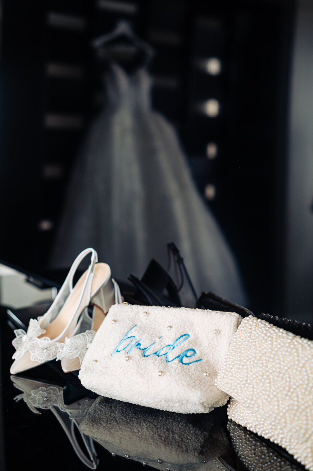 Bridal accessories — ivory lace shoe and pearl-studded purse — arranged for photographic flatlay.