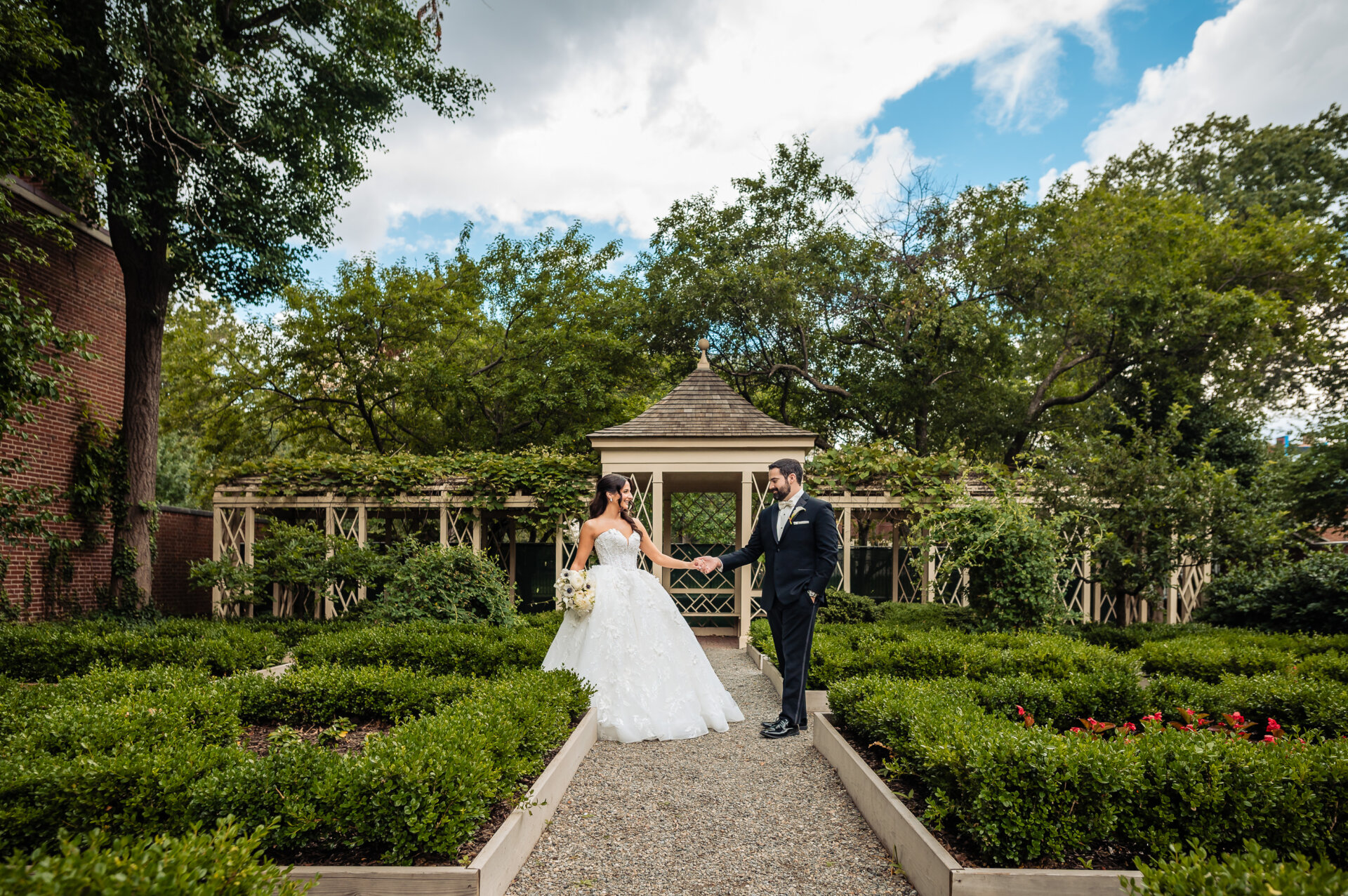 Newly pronounced husband and wife posing together in a garden, captured in a relaxed post-ceremony portrait.