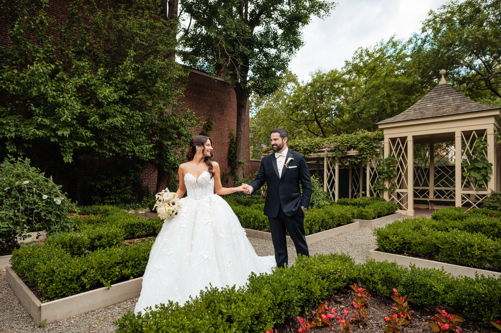 Newly pronounced husband and wife posing together for a post-ceremony portrait in a garden setting.