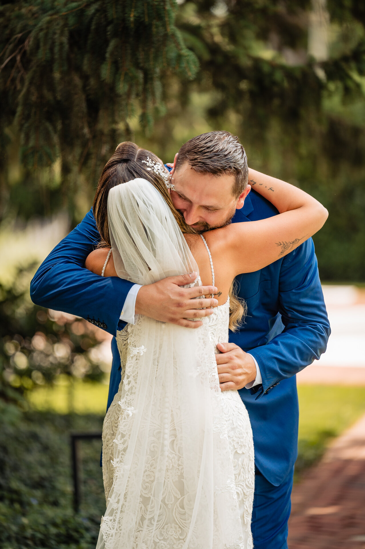 Groom hugs his bride tightly during their first look before the wedding ceremony.