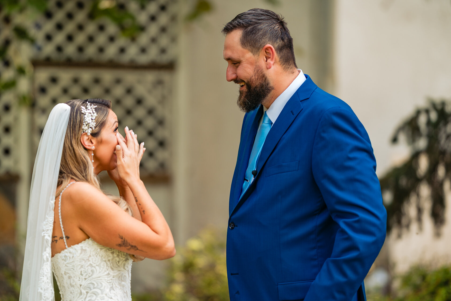 Bride reacting emotionally during the ceremony while facing the groom outdoors