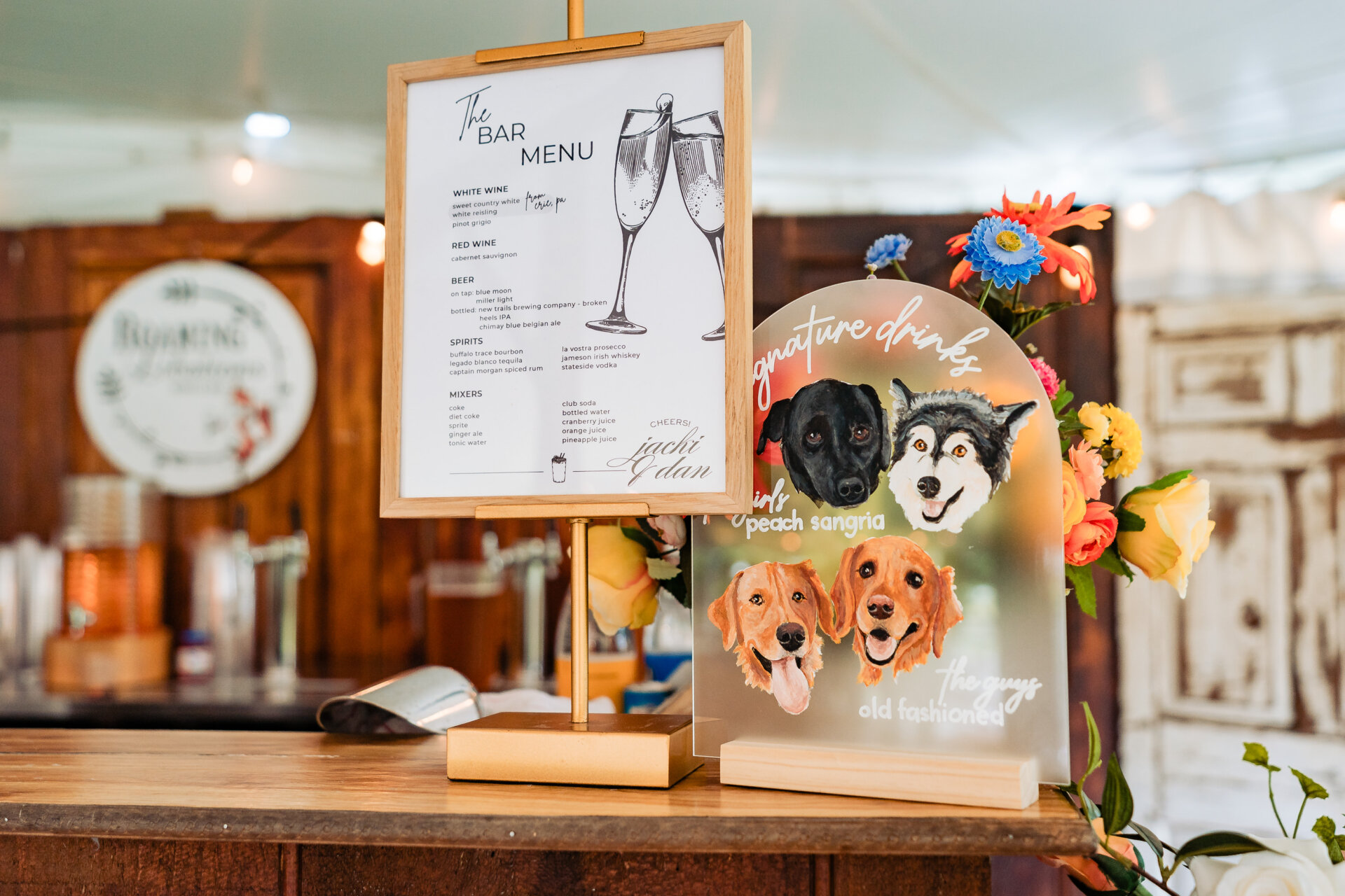Wedding bar setup with custom bar menu and illustrated signature drinks sign featuring the couple’s dogs