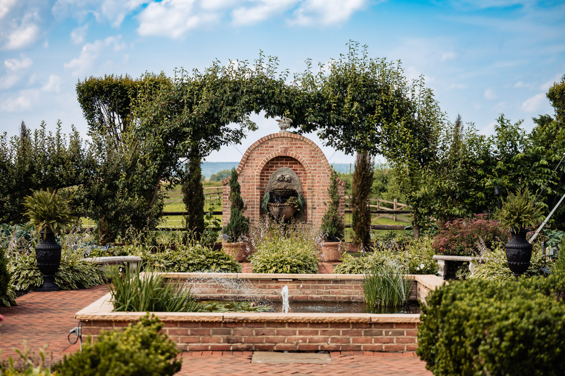 Outdoor garden fountain and brick pathway at the wedding venue of white chimney estate
