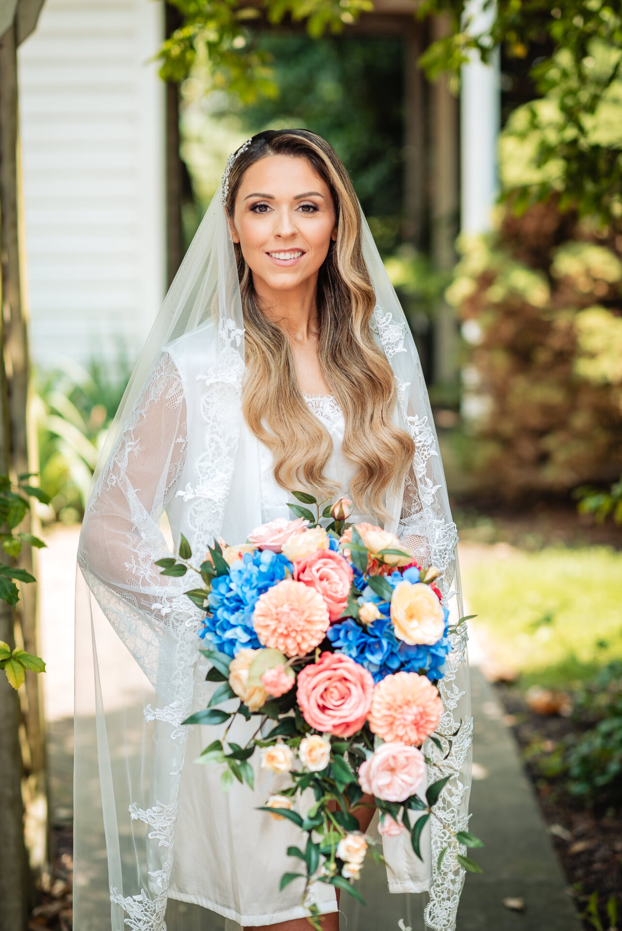 Bride poses in her pyjamas while holding her bouquet during a relaxed wedding morning portrait.
