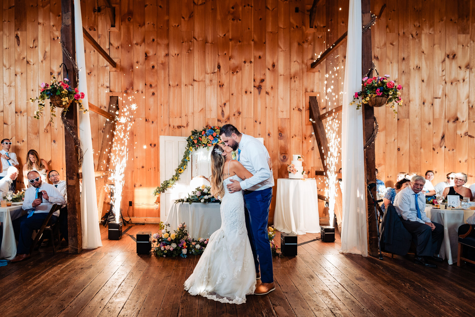 Bride and groom sharing a kiss on the dance floor surrounded by sparklers during the reception