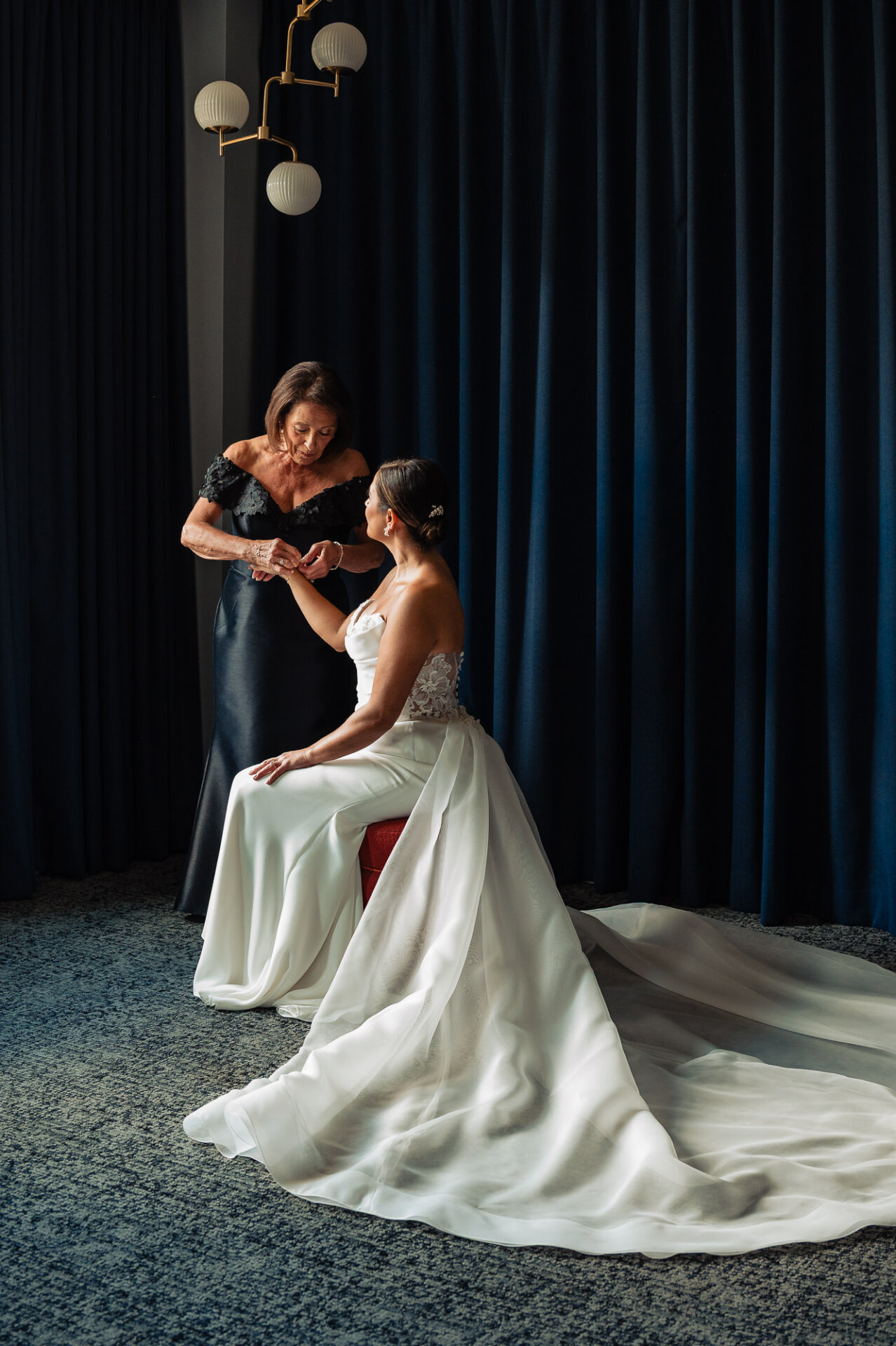 Mother fastening bride’s bracelet during wedding prep