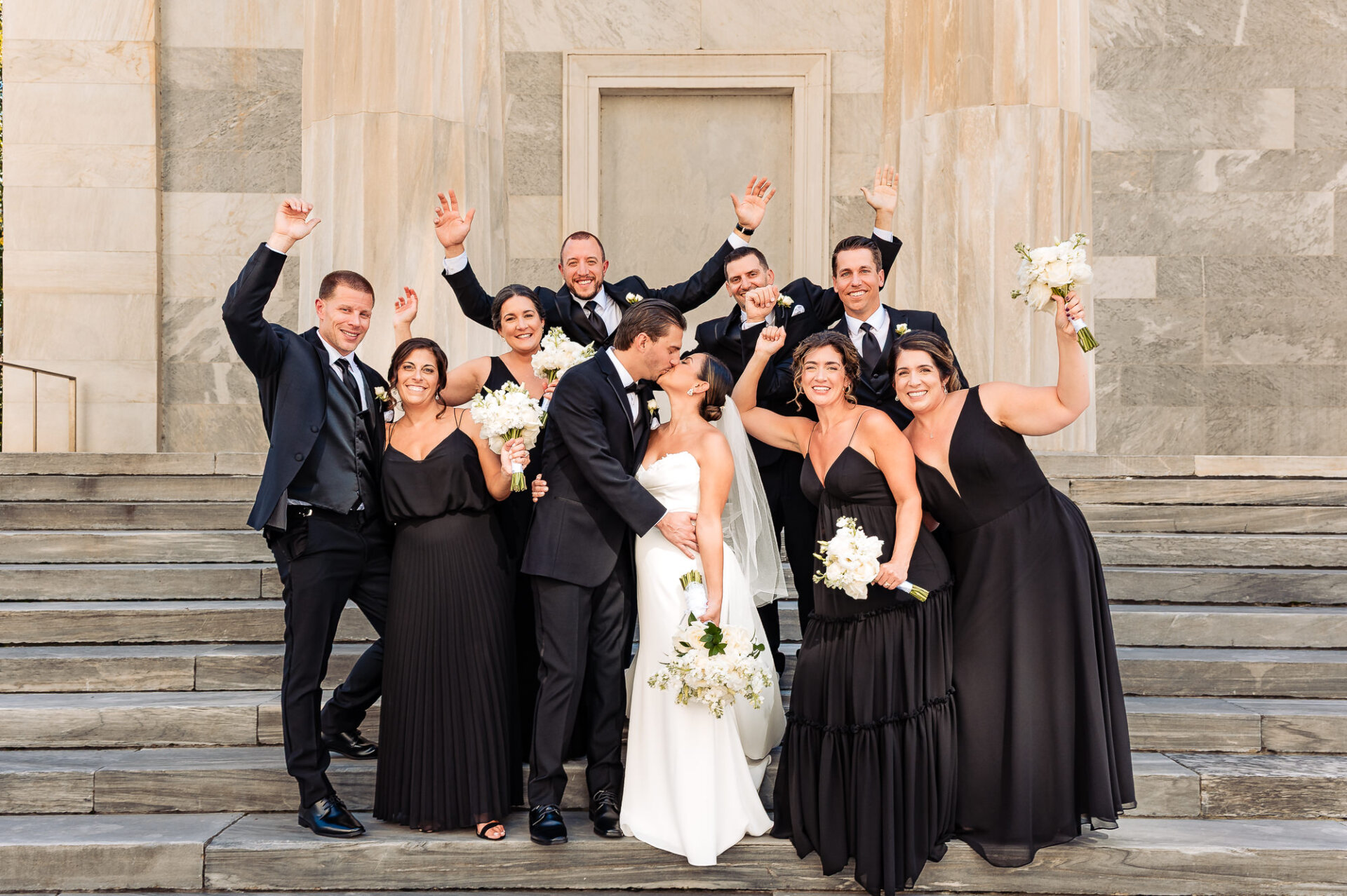 Bride and groom celebrating with wedding party on Union Trust steps