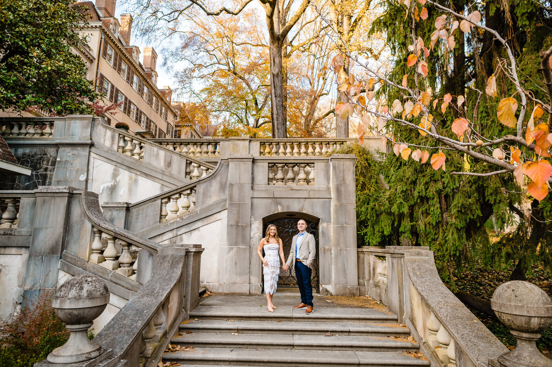 Couple taking a pose on the stone steps at Winterthur Gardens in fall
