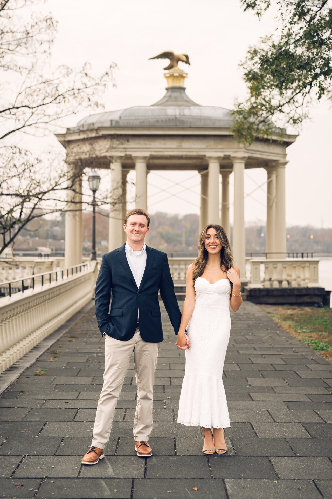 Couple holding hands while walking on the lawn near the Philadelphia Art Museum.