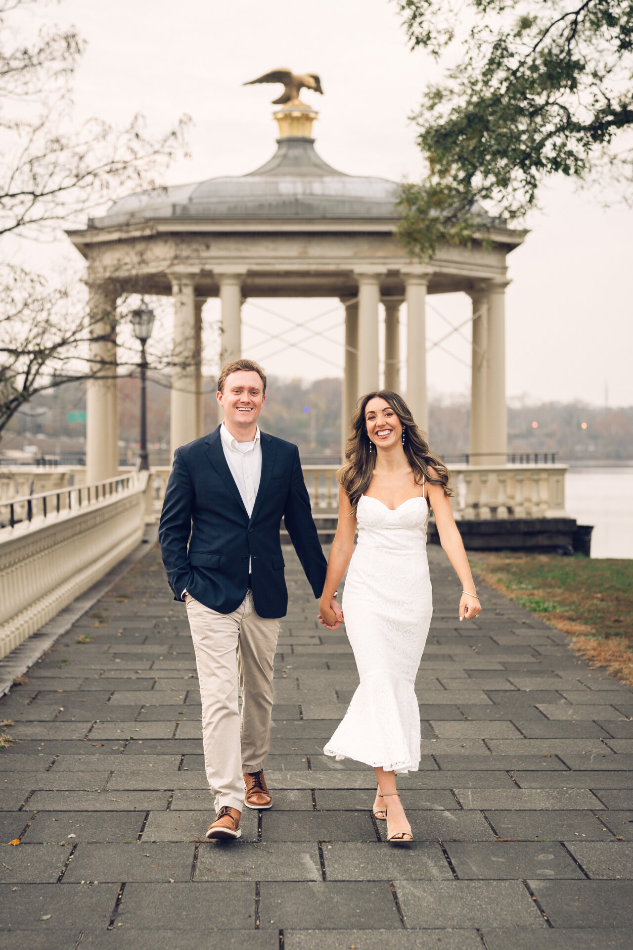 Couple holding hands while walking on the lawn near the Philadelphia Art Museum.
