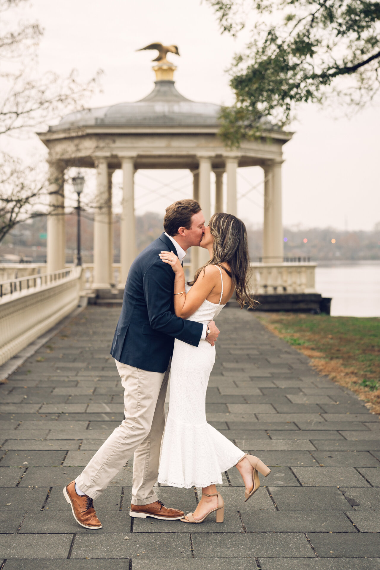 Couple sharing a kiss along the Philadelphia Waterworks walkway.