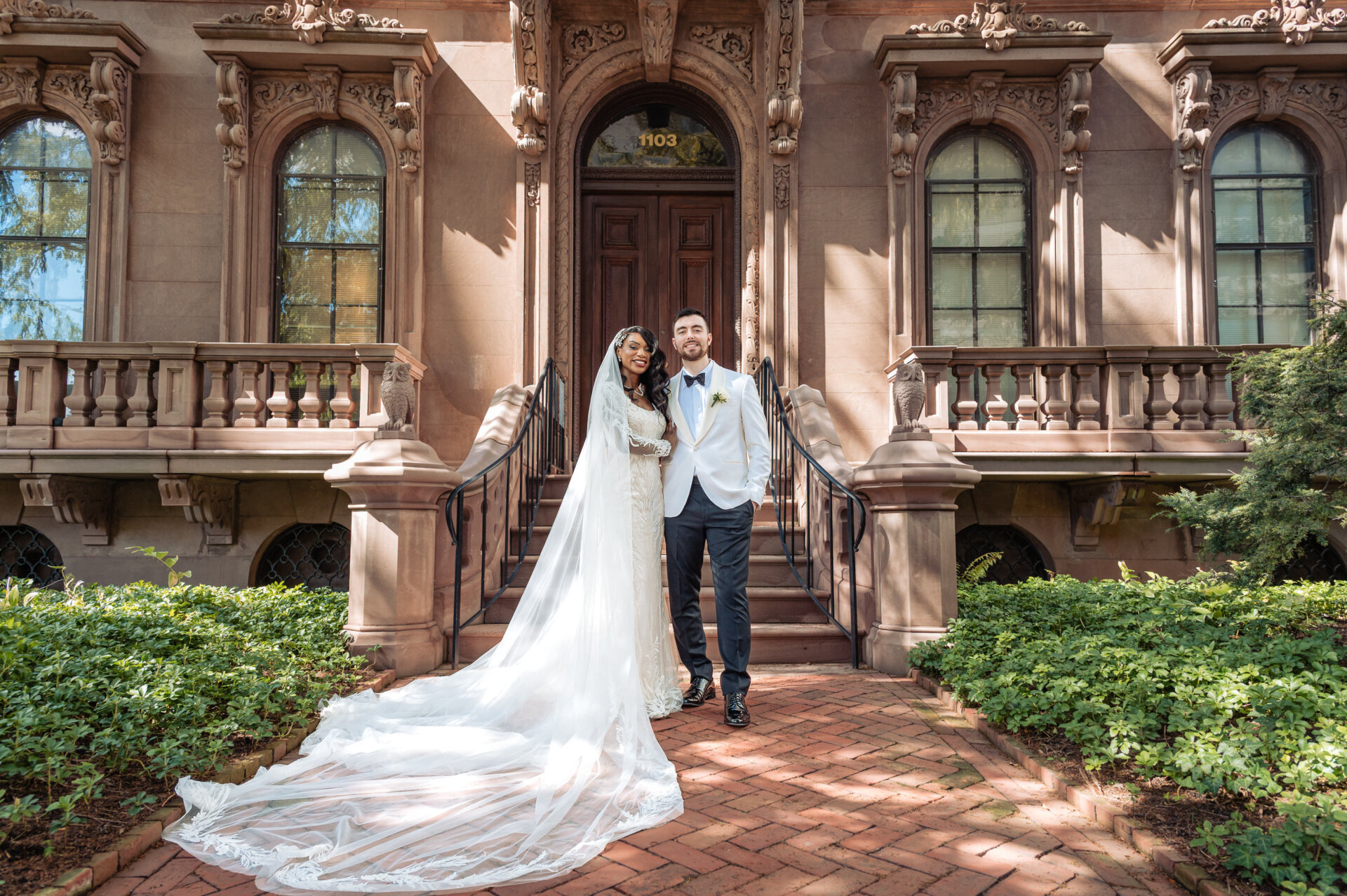 Bride and groom standing together on the front steps of a historic mansion at Hotel DuPont.
