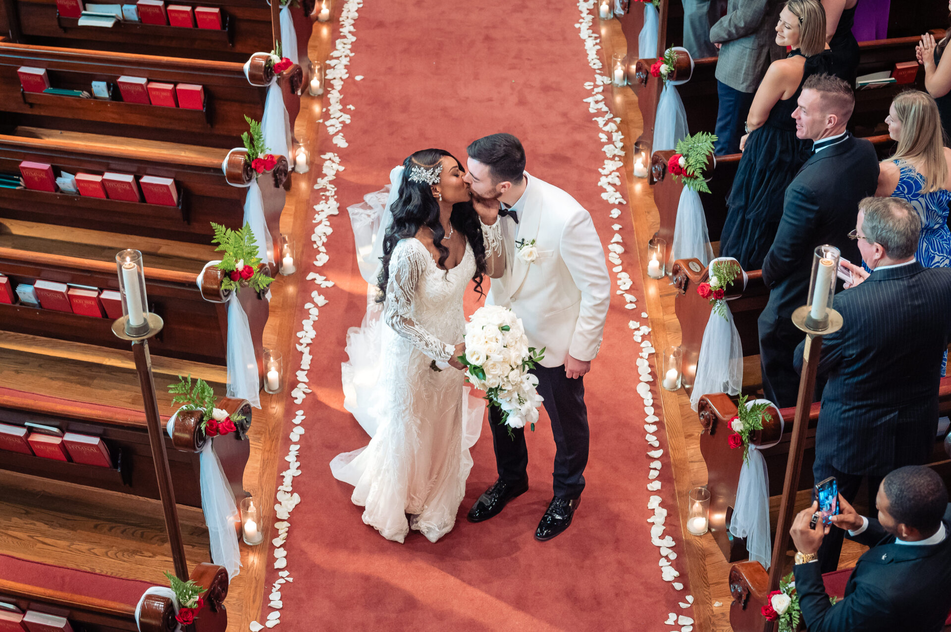 Bride and groom walking down the aisle together after the ceremony as guests look on from both sides.