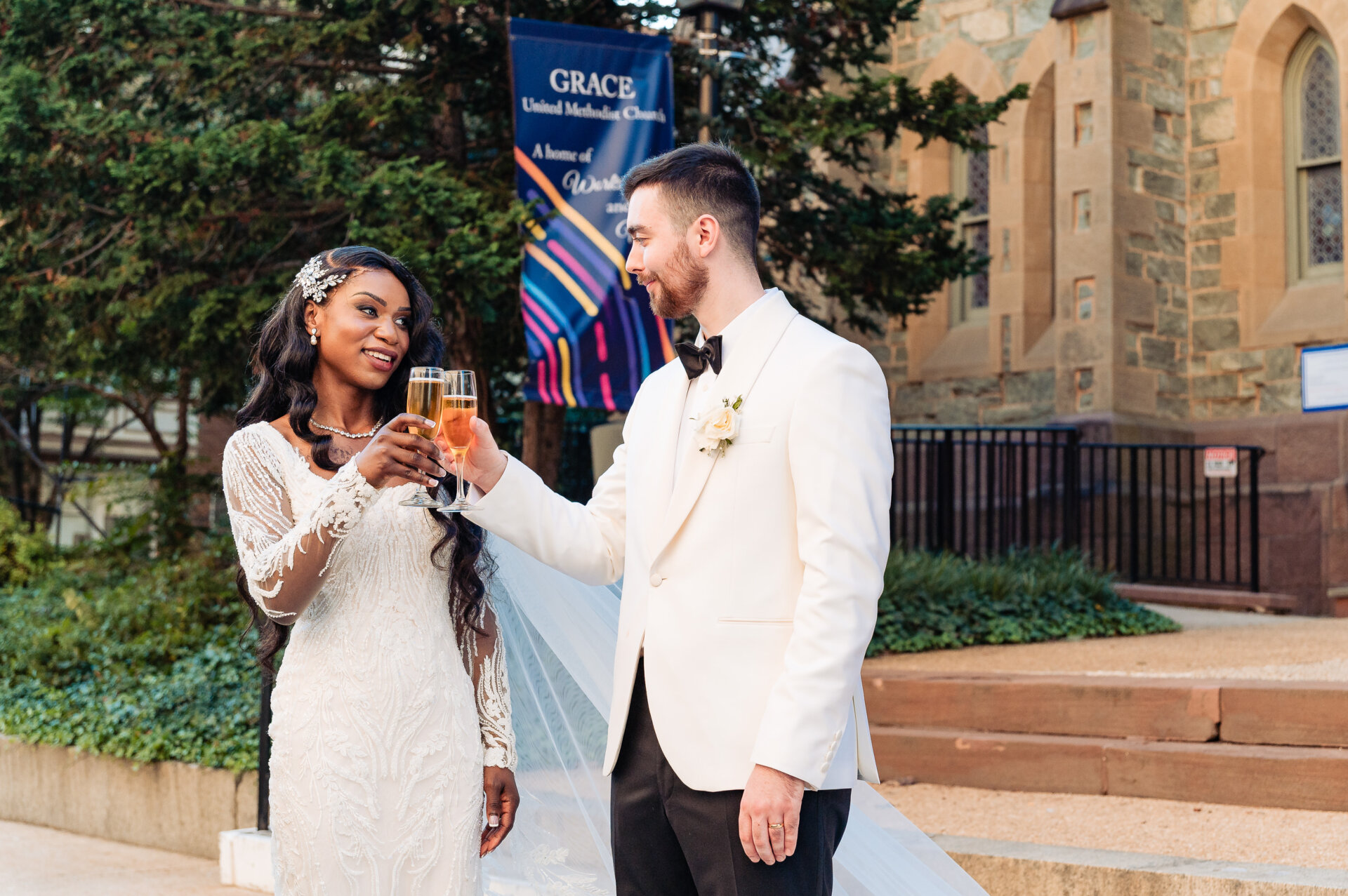 Bride and groom toasting with champagne outside the church following their wedding ceremony.
