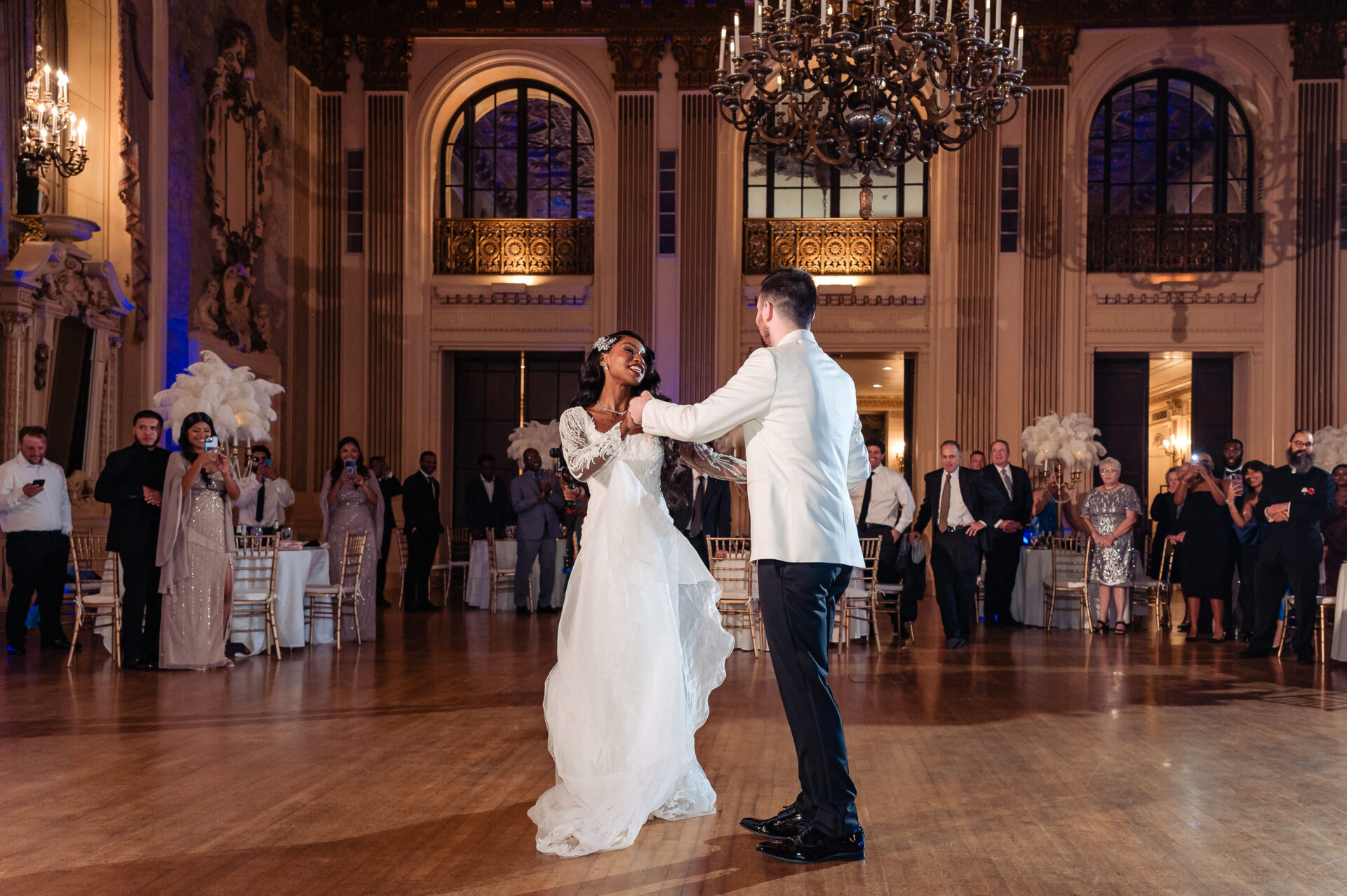 Bride and groom sharing their first dance in the Hotel DuPont ballroom surrounded by guests.