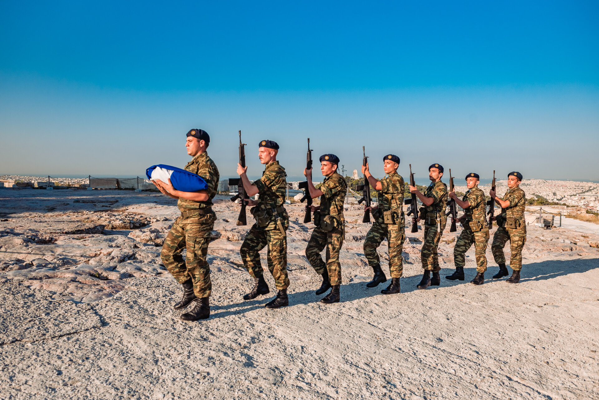 Greek army soldiers perform a ceremonial march past the Parthenon temple before raising the national flag on Acropolis Hill.