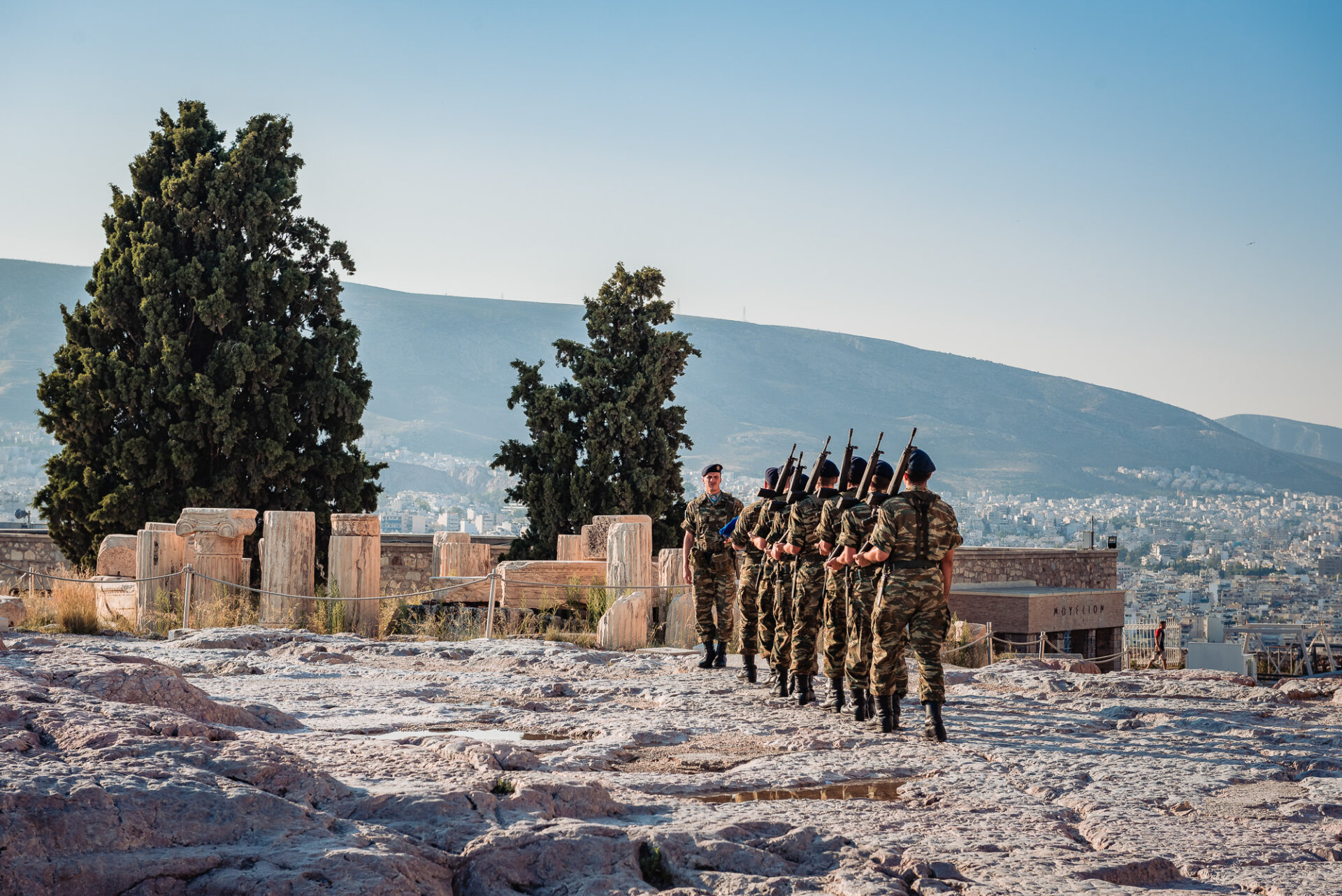 Greek army soldiers perform a ceremonial march past the Parthenon temple before raising the national flag on Acropolis Hill.