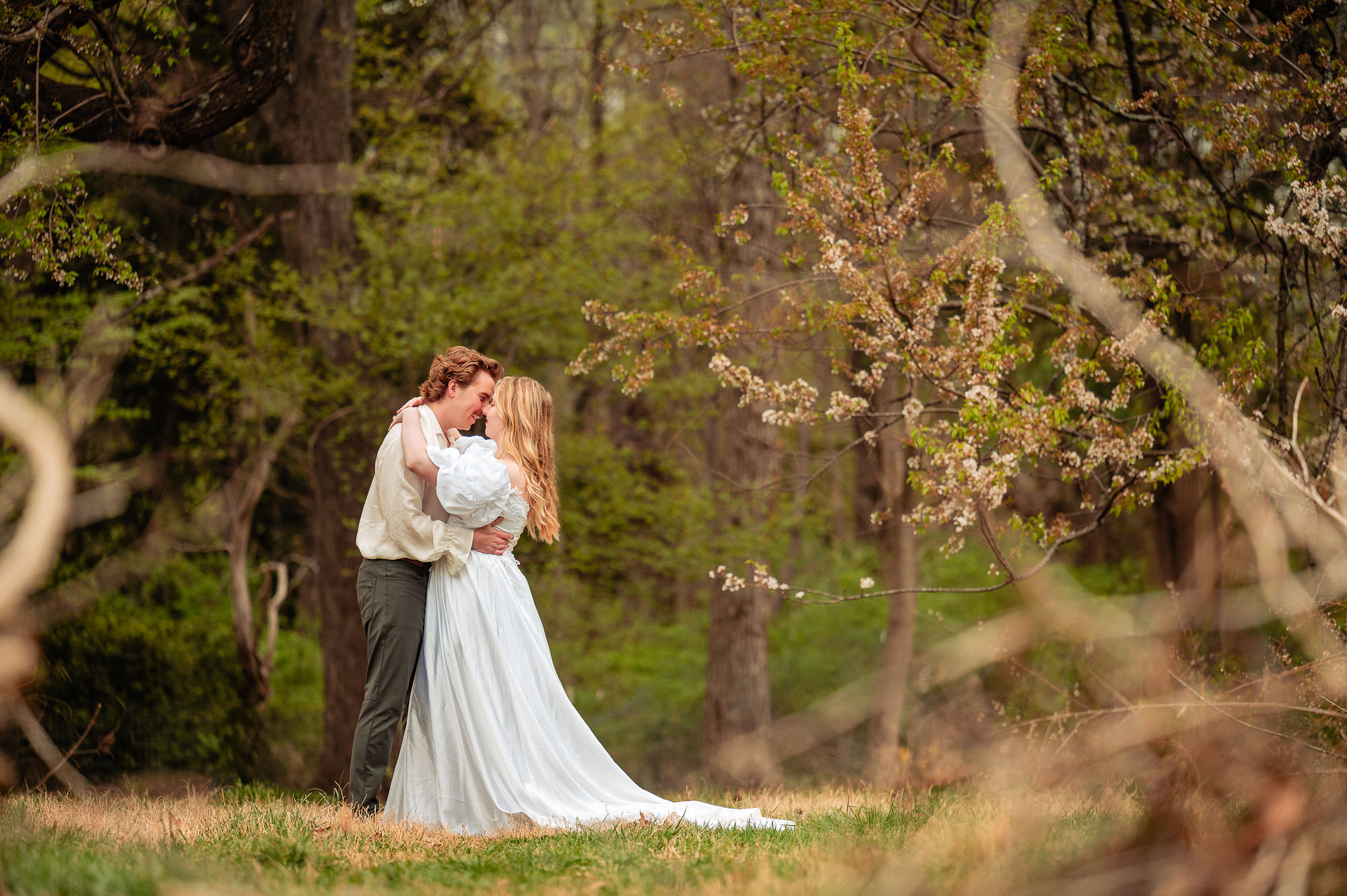Couple embracing under blooming trees during Georgetown D.C. engagement session in spring
