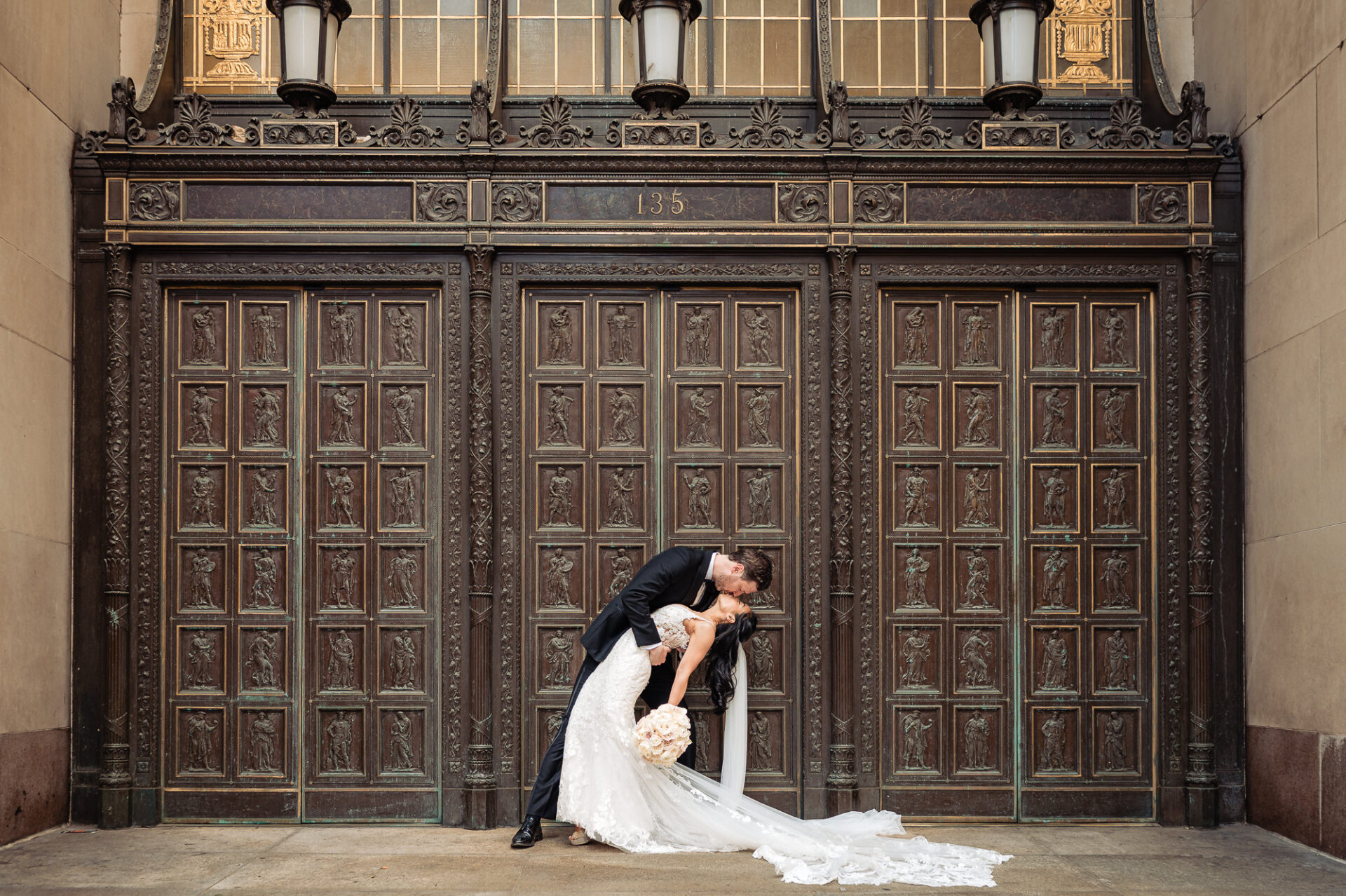 Romantic dip kiss in front of Union Trust’s iconic bronze entrance doors