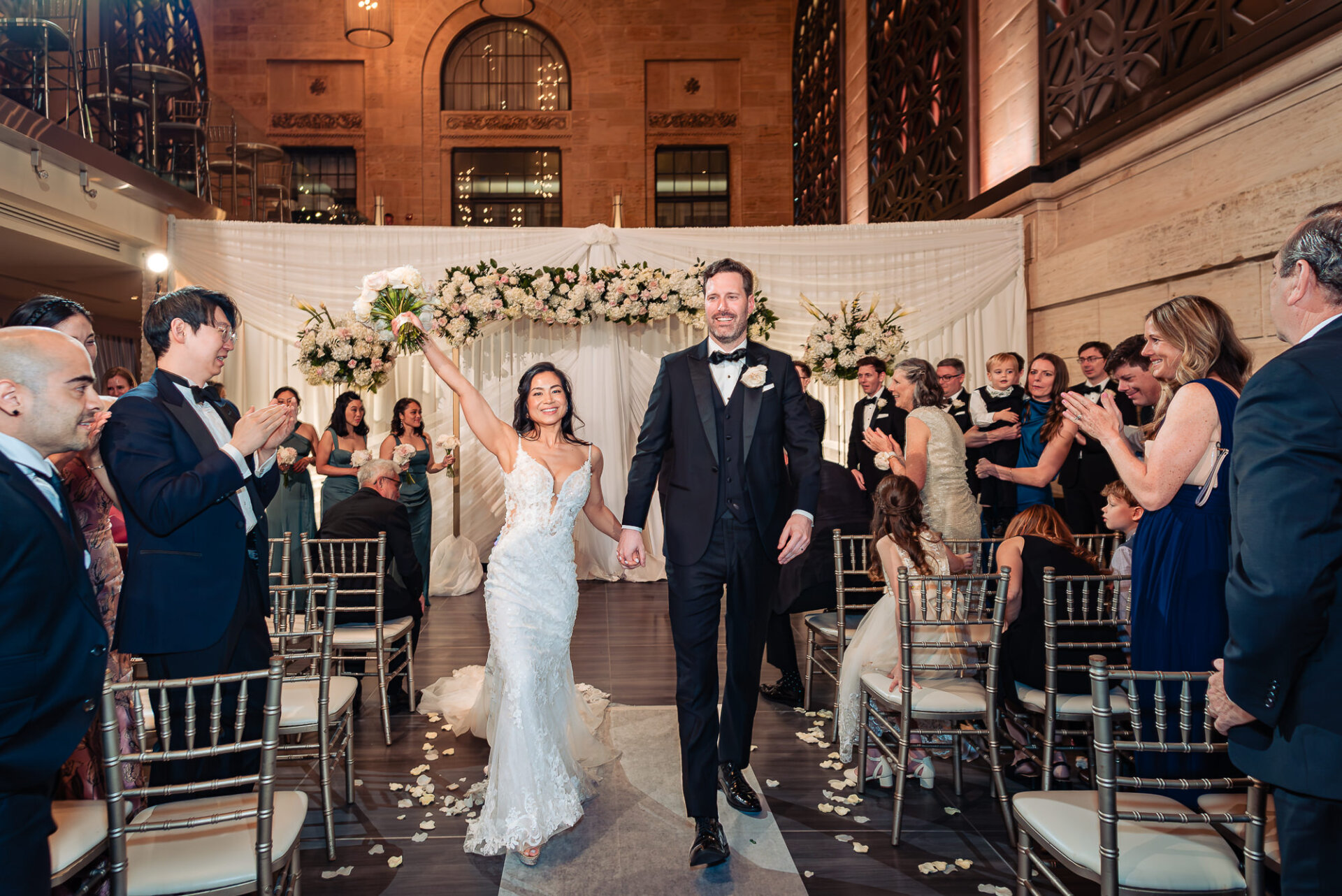 Newlyweds celebrate their marriage with a joyful recessional through family and friends