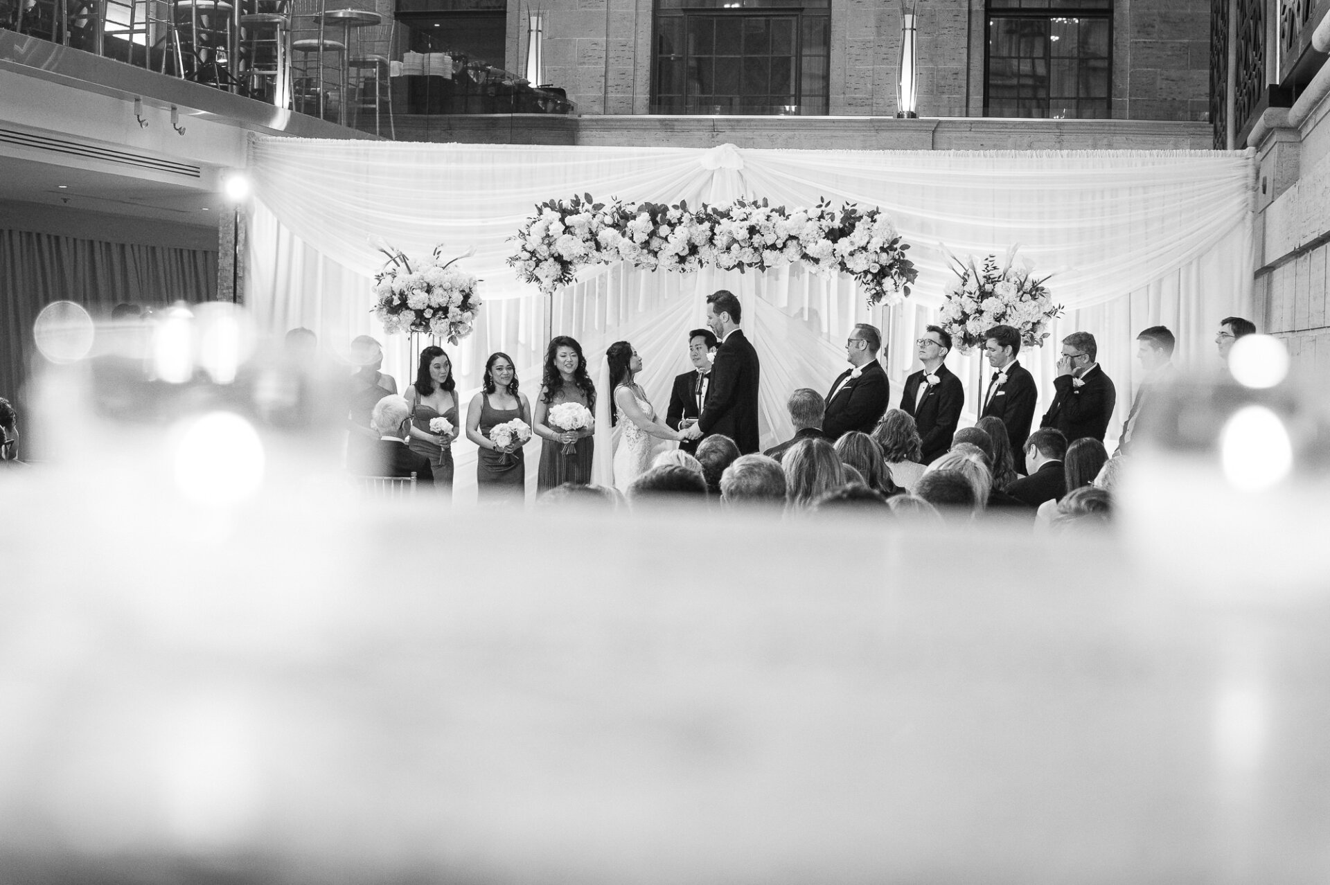 Black-and-white ceremony photograph capturing Kim and Greg exchanging vows
