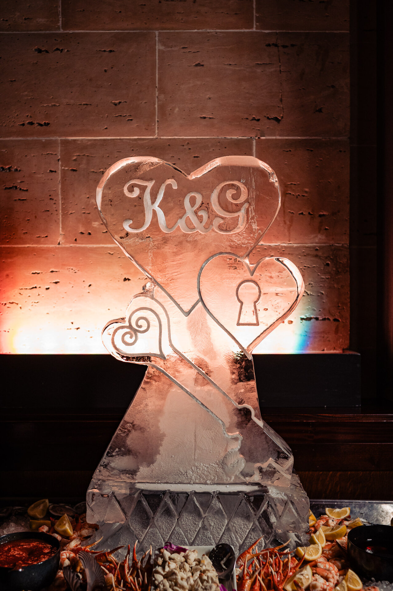 Custom ice sculpture display featuring the couple’s initials and lock-and-key design