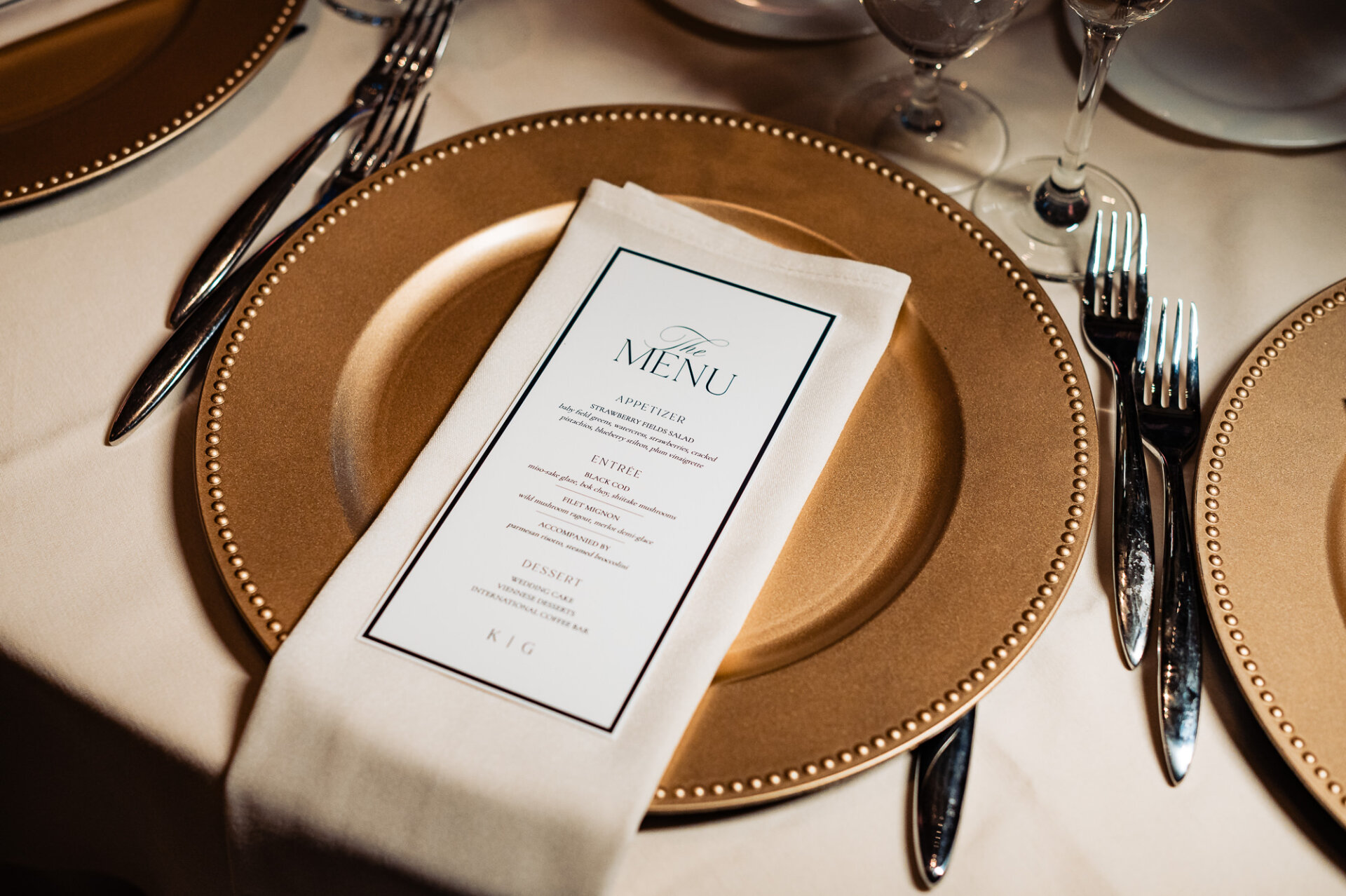 Elegant wedding menu styling with gold charger plates and refined reception details