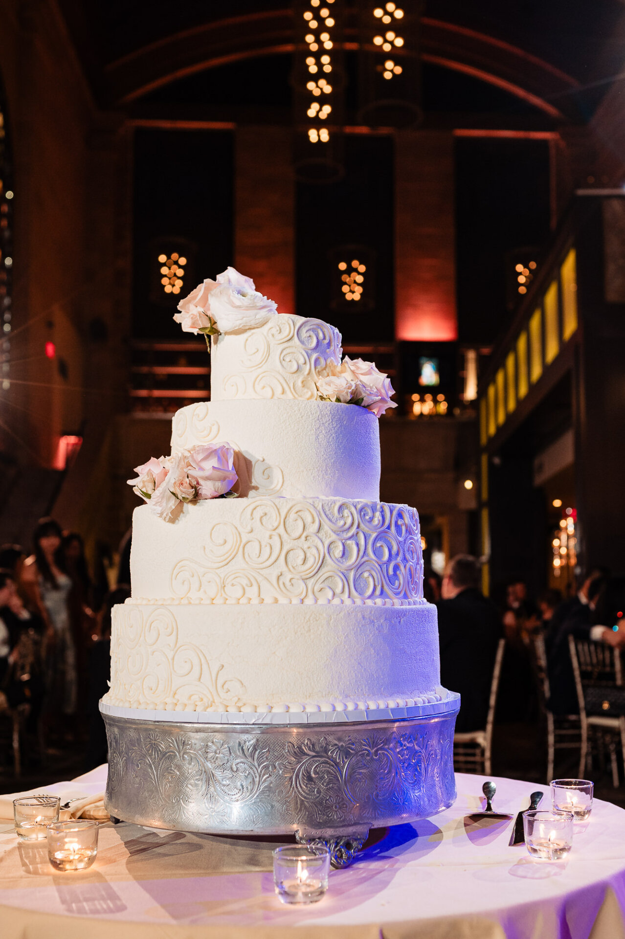 Four-tier wedding cake with textured detailing and blush floral accents at Union Trust