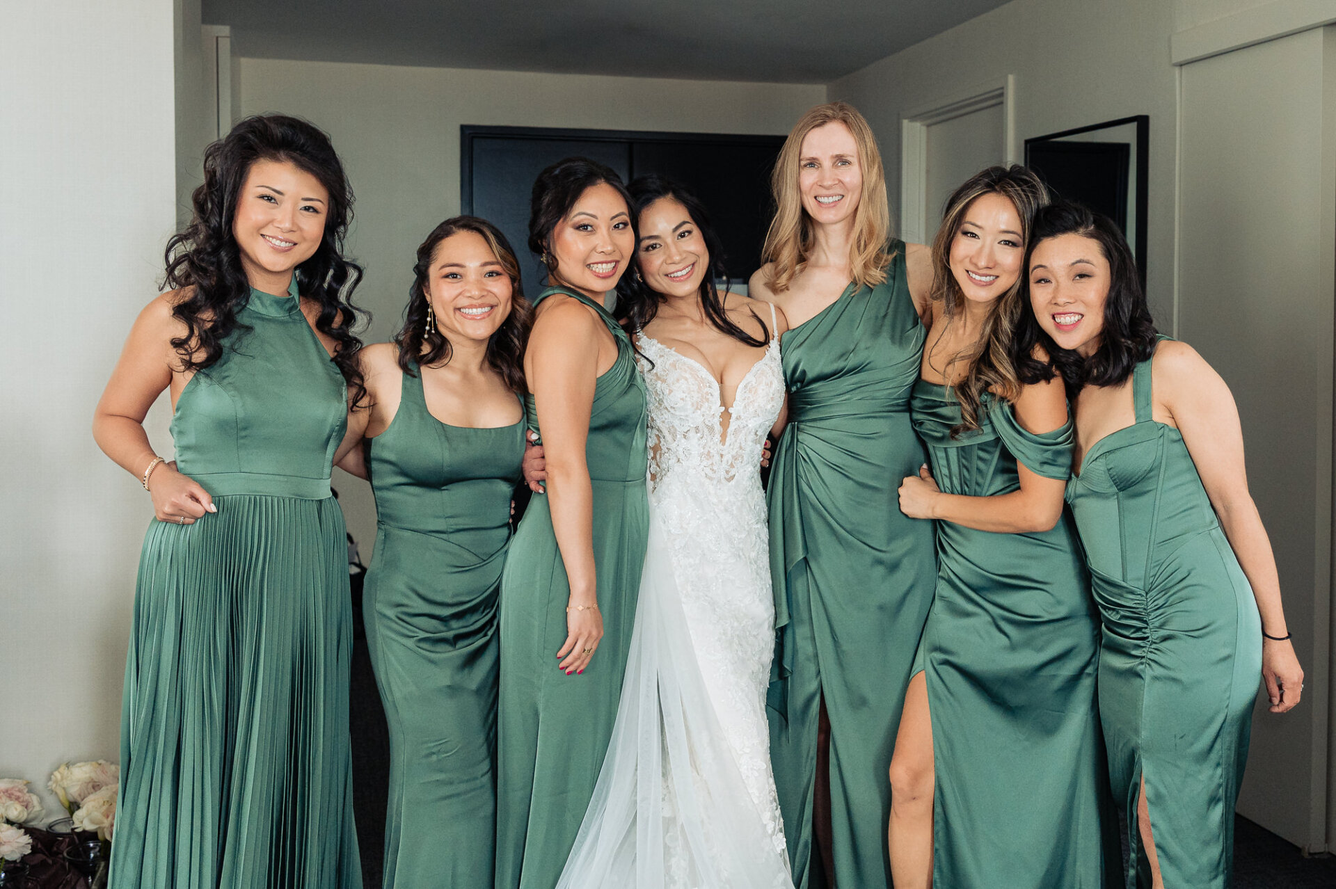 Bridal party portrait featuring the bride and bridesmaids in coordinated sage green dresses