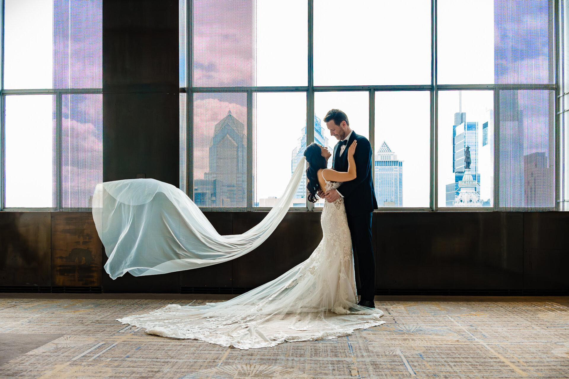 Romantic Union Trust wedding portrait with a flowing veil and Philadelphia skyline views