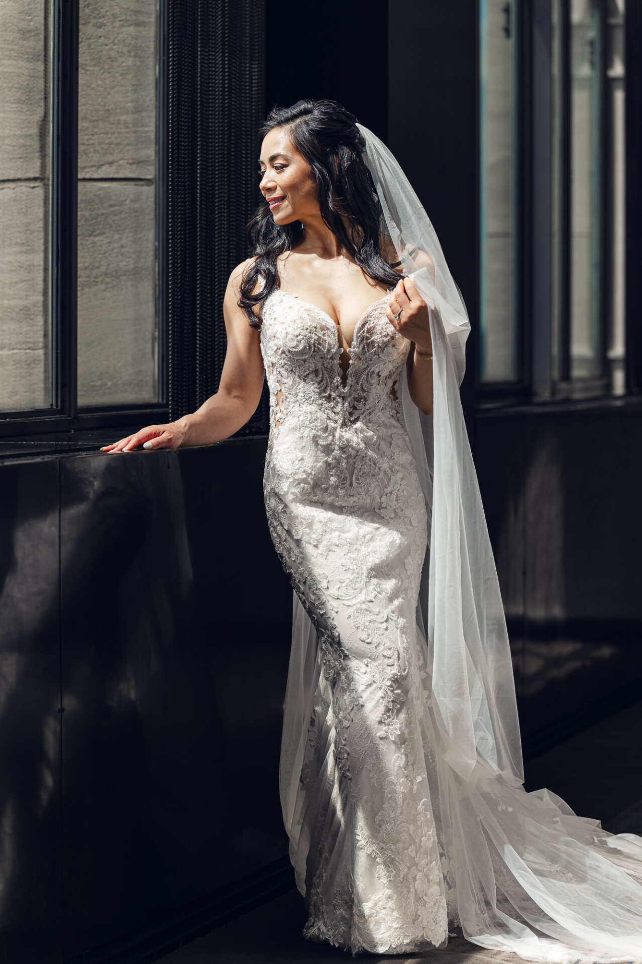legant bridal portrait by the window showcasing intricate lace gown details and natural light