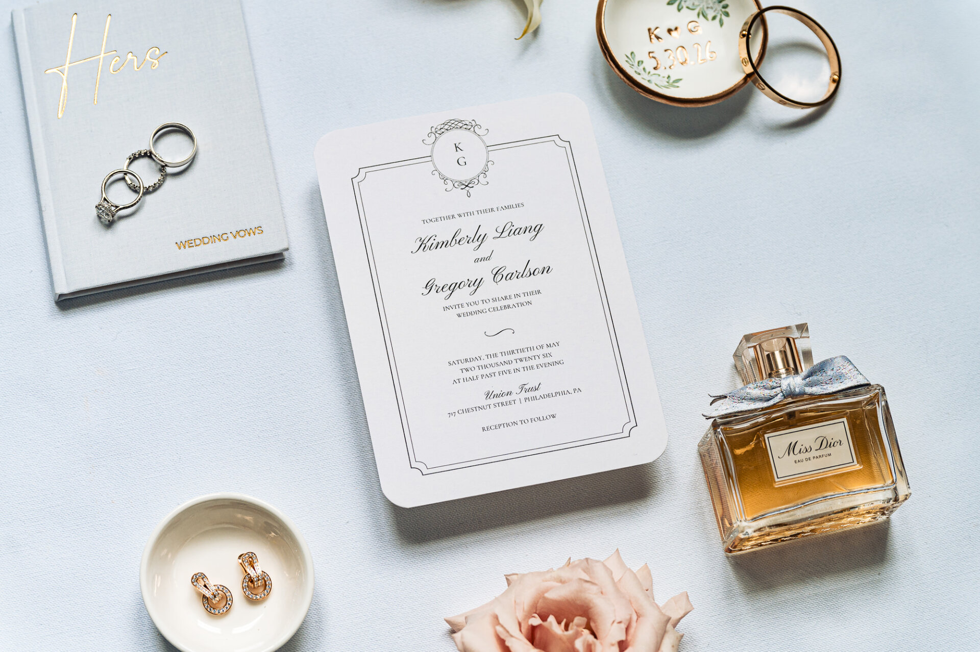 Flat lay of wedding invitation suite, rings, perfume and bridal accessories for a Union Trust wedding
