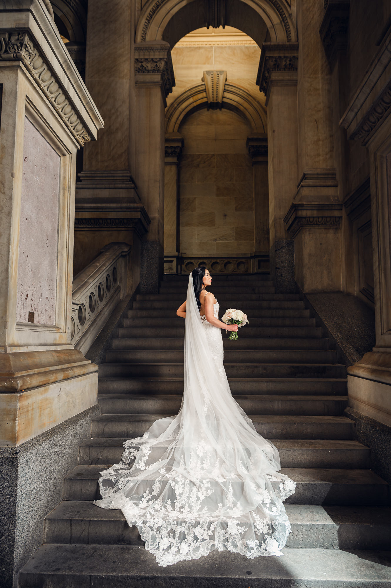 Bridal portrait on Union Trust’s grand staircase highlighting a dramatic cathedral-length veil