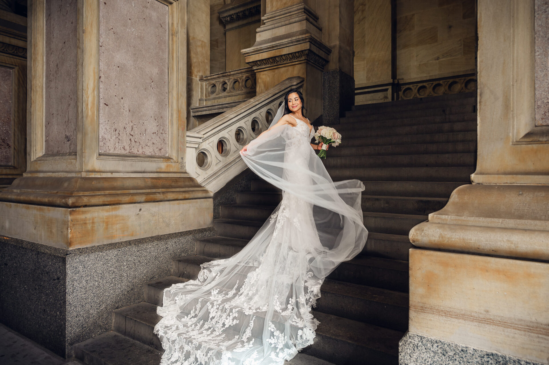 Bride posing on the staircase with flowing veil during Union Trust wedding portraits