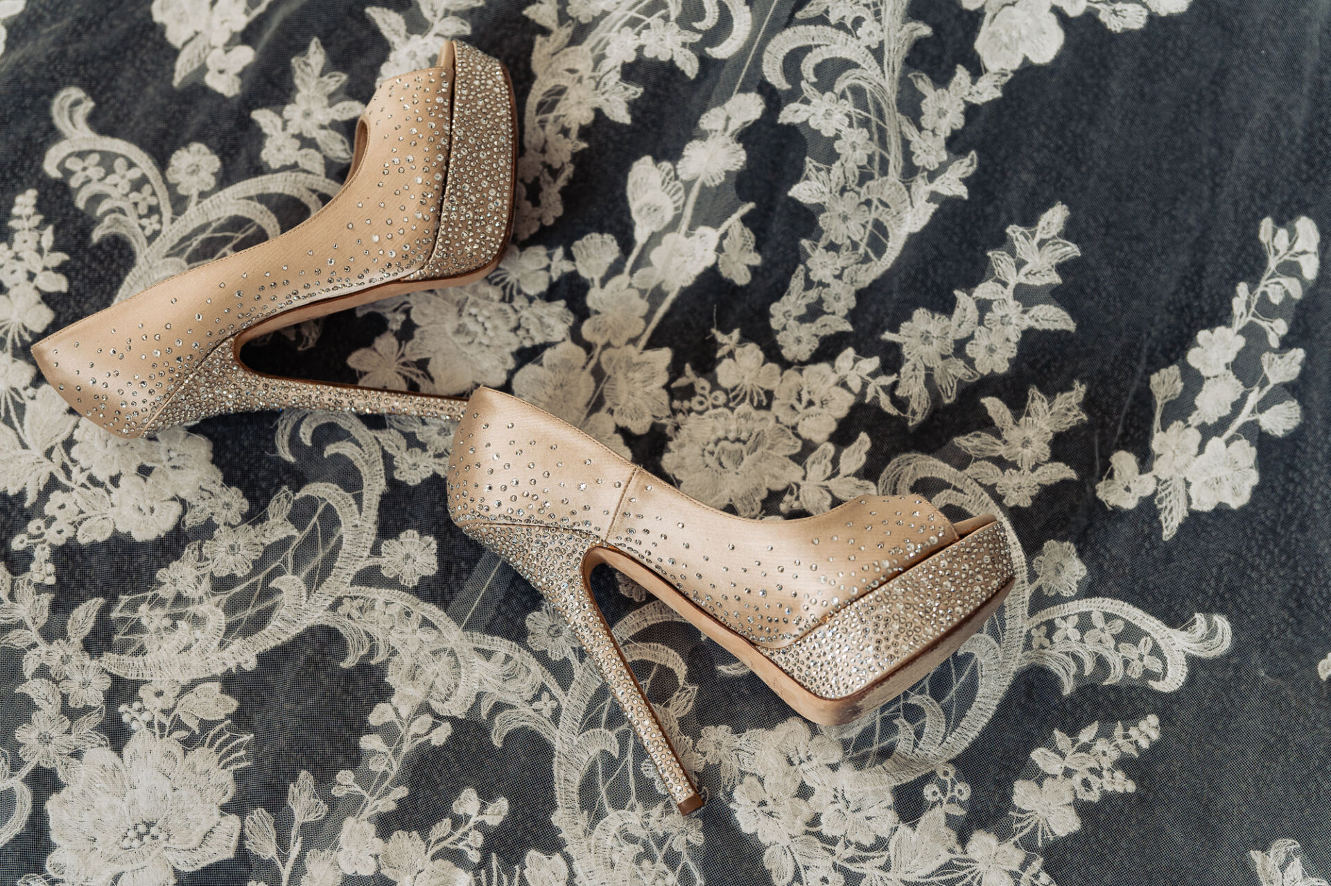 Luxury bridal shoe detail featuring sparkling wedding heels and lace wedding gown accents