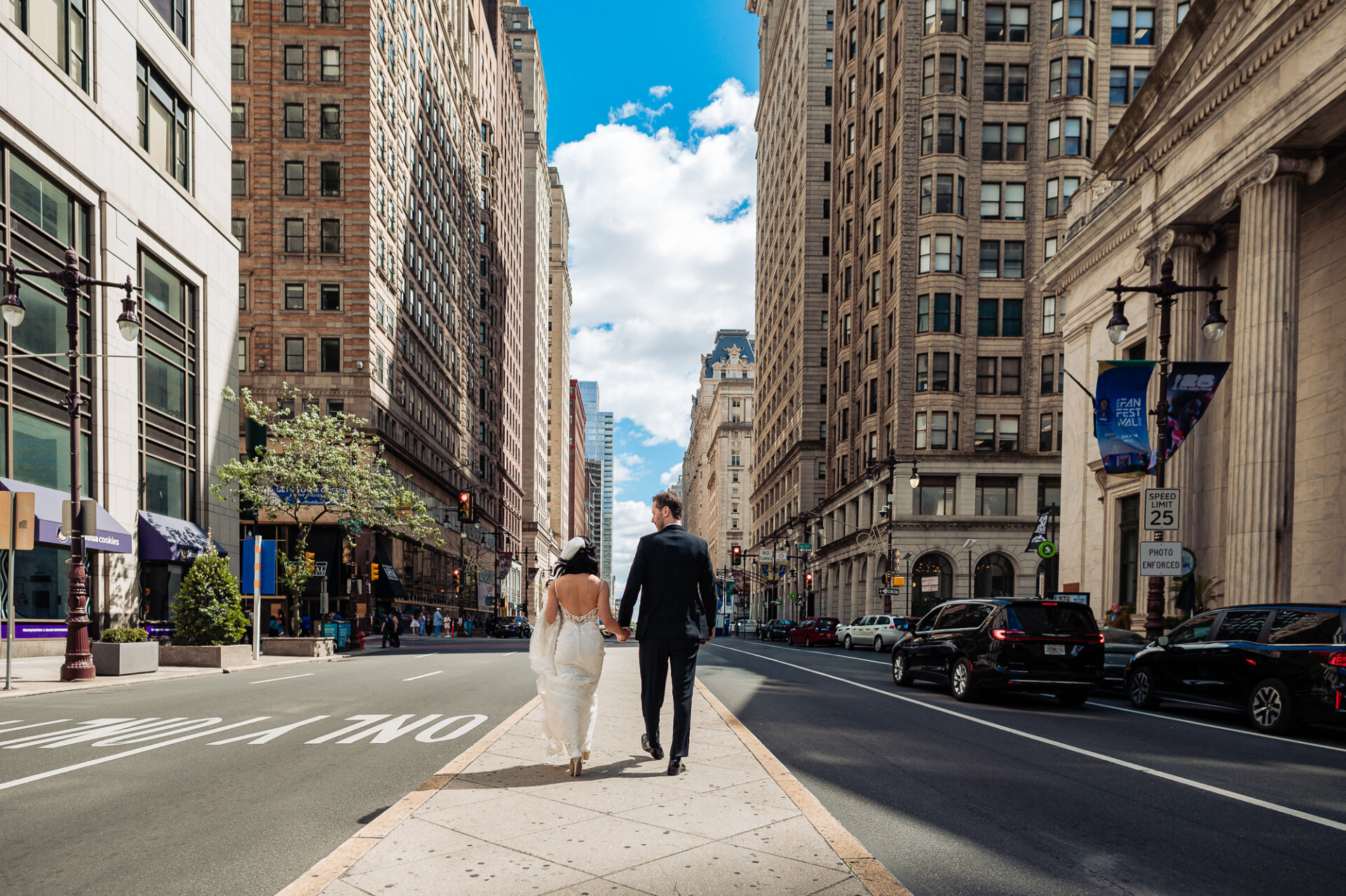 Newlyweds walking through downtown Philadelphia after their Union Trust wedding ceremony