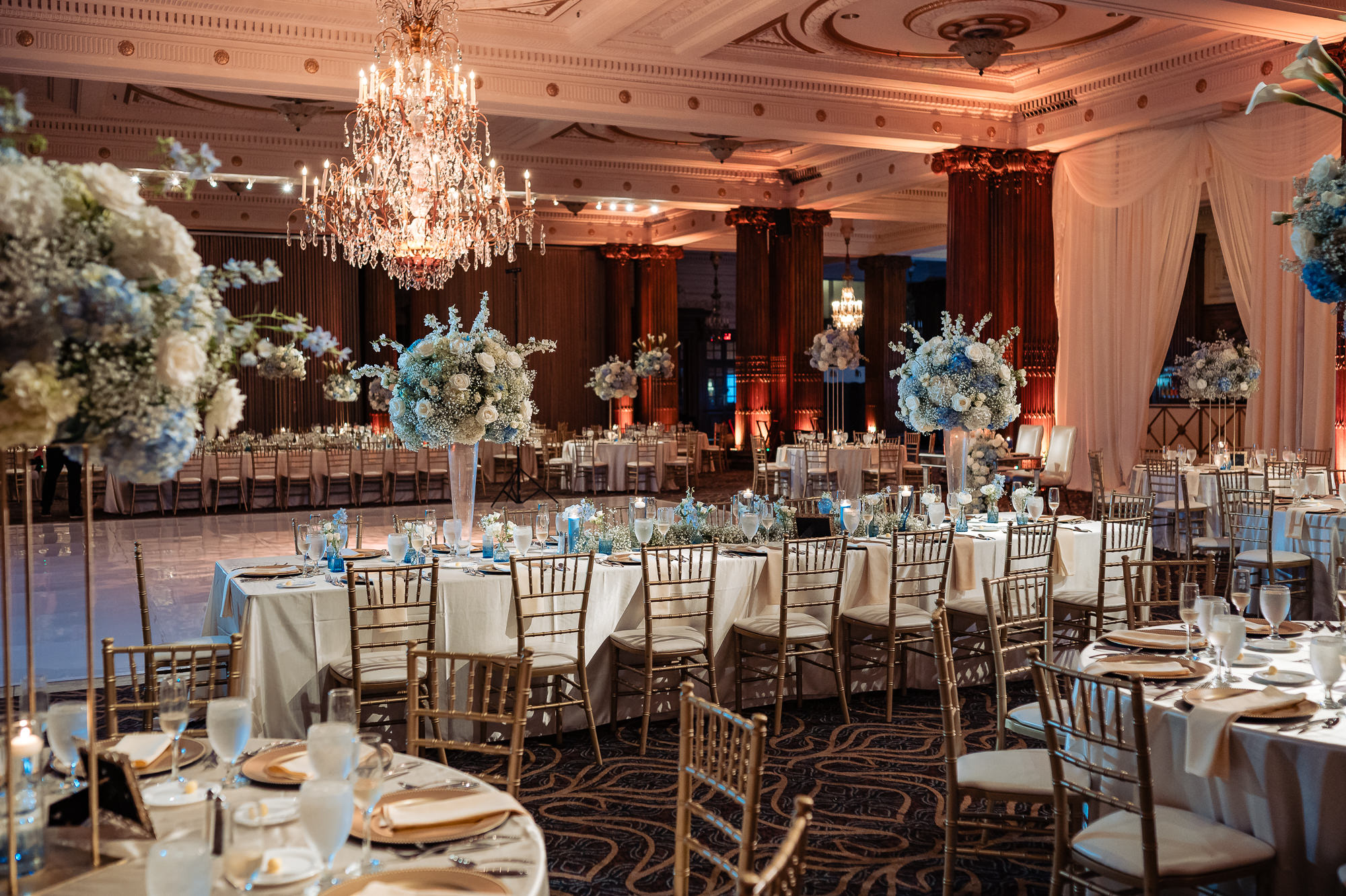 Crystal Tea Room reception featuring grand chandeliers, blue and white florals, and formal table settings