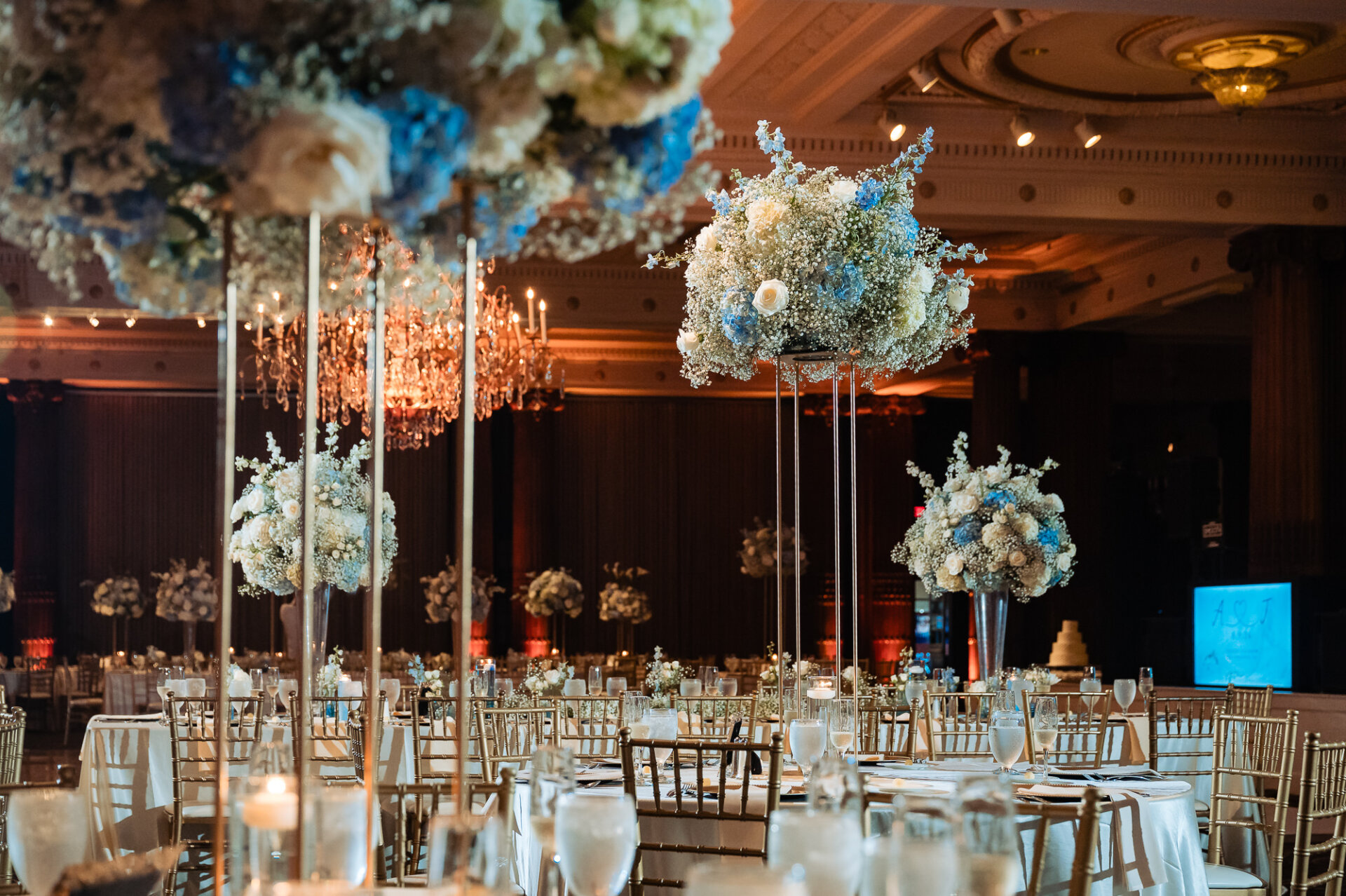Crystal Tea Room wedding reception with tall blue and white floral centerpieces and candlelit tables