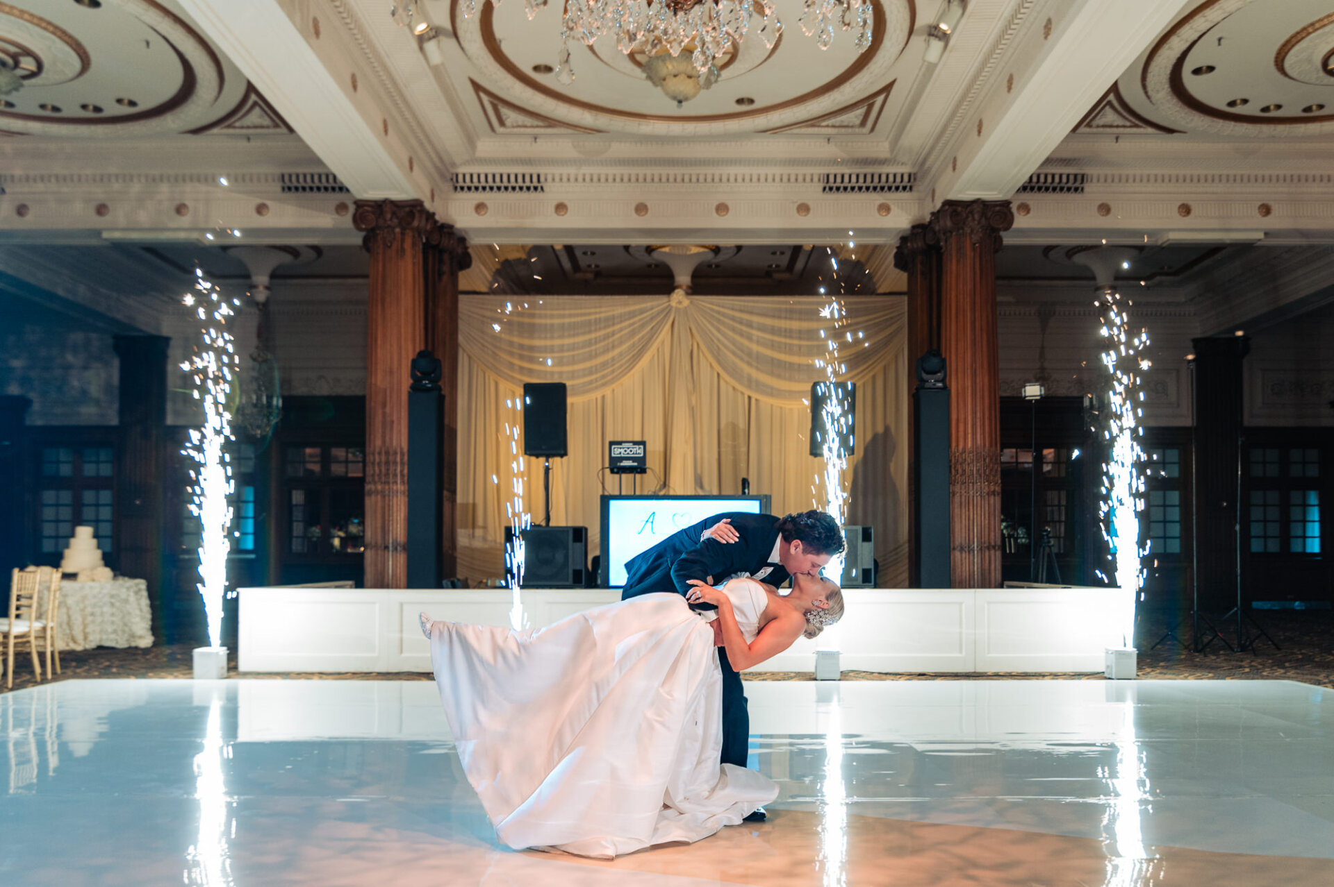 Bride and groom sharing a dramatic dip kiss with indoor sparkler fountains at the Crystal Tea Room