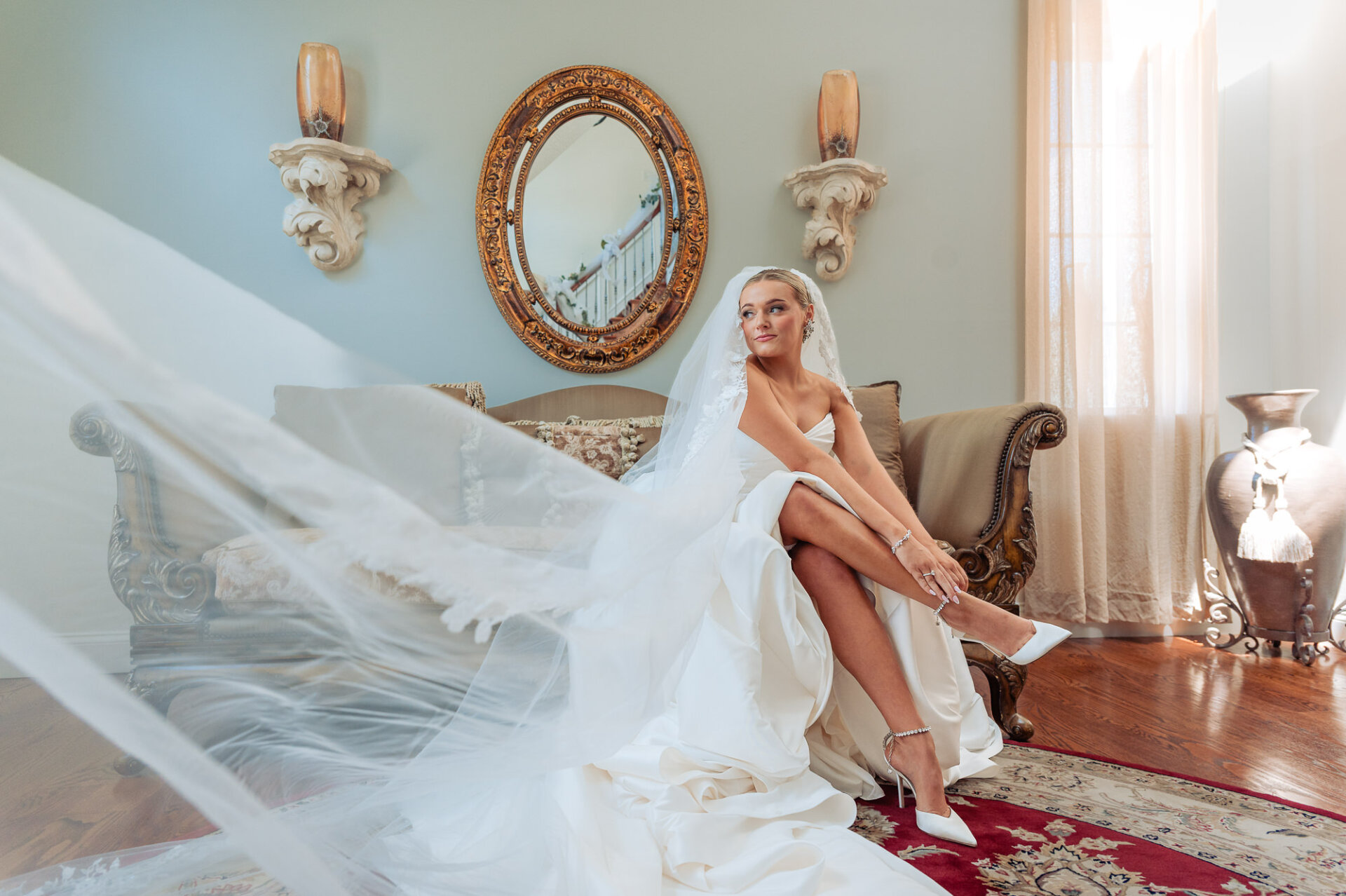 Bride seated in her wedding gown while putting on white heels before the ceremony