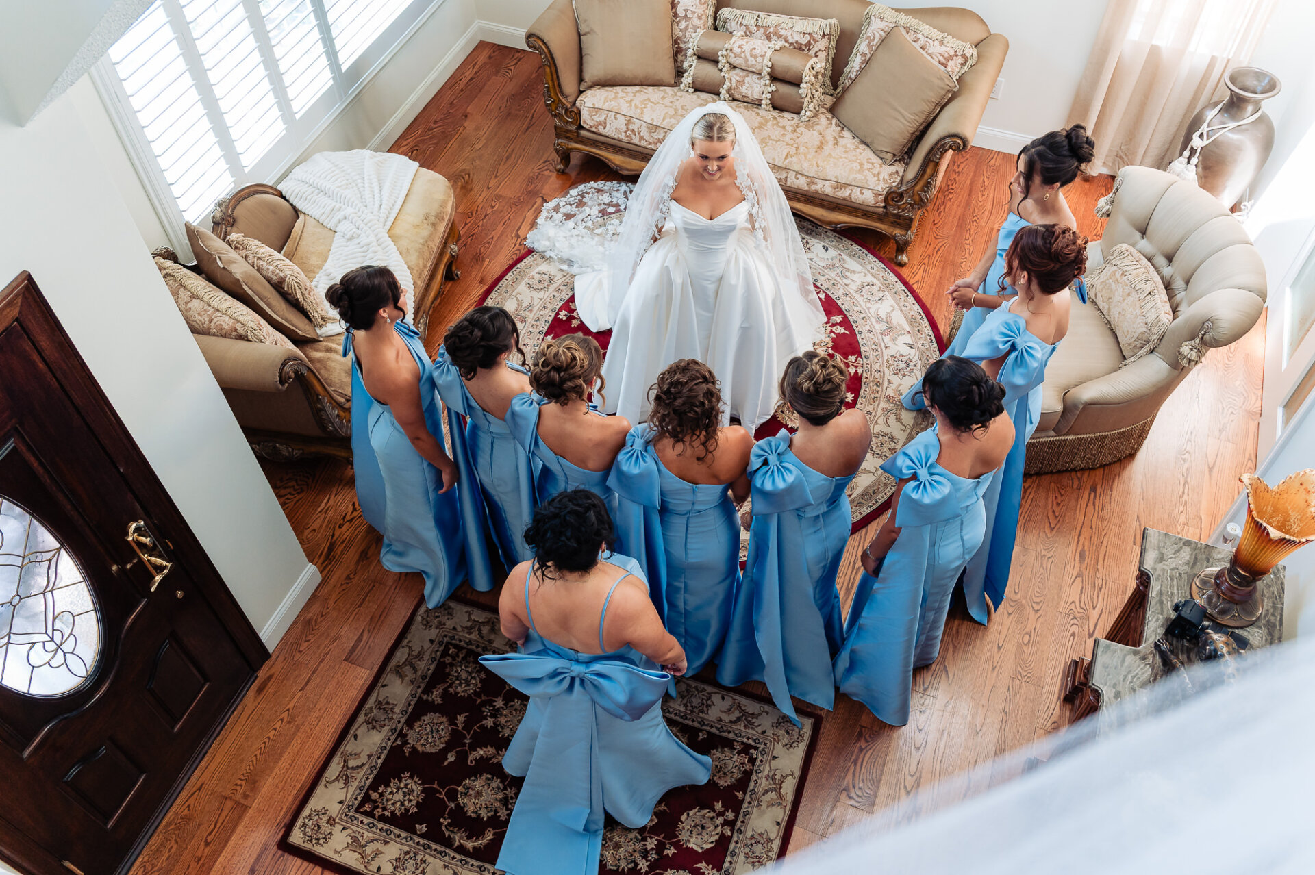 Overhead view of the bride surrounded by bridesmaids in matching light blue dresses before the ceremony