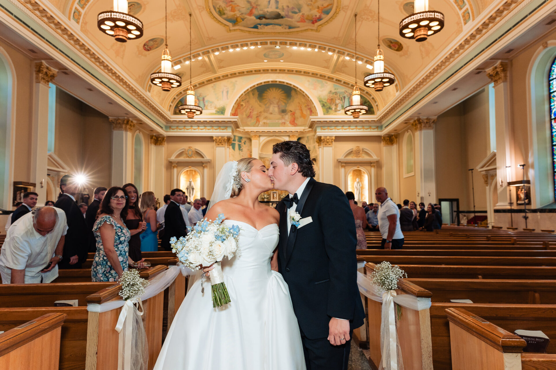 Newlyweds sharing a kiss in the church aisle after their wedding ceremony