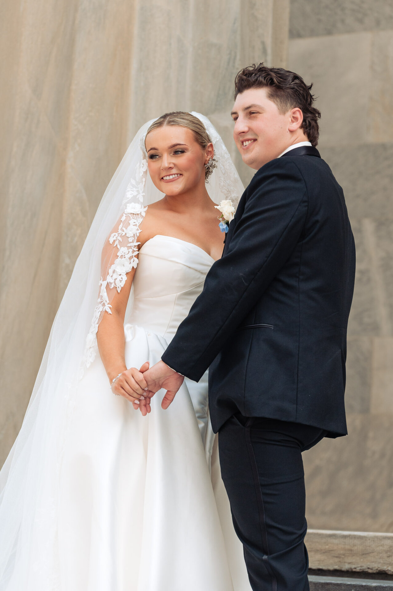 Bride and groom holding hands during a classic outdoor wedding portrait