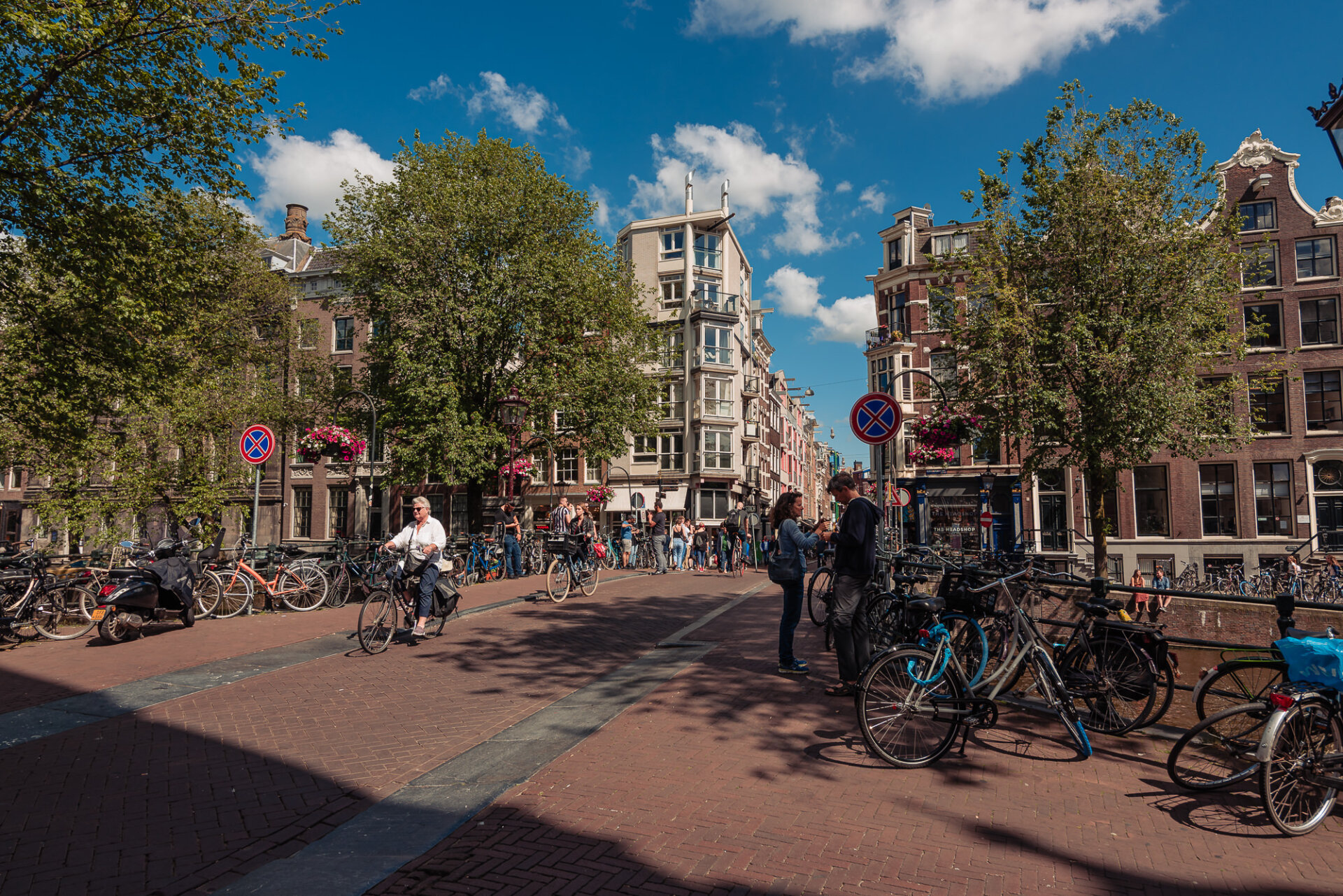299. Cyclists, pedestrians and rows of parked bicycles along a lively Amsterdam canal street