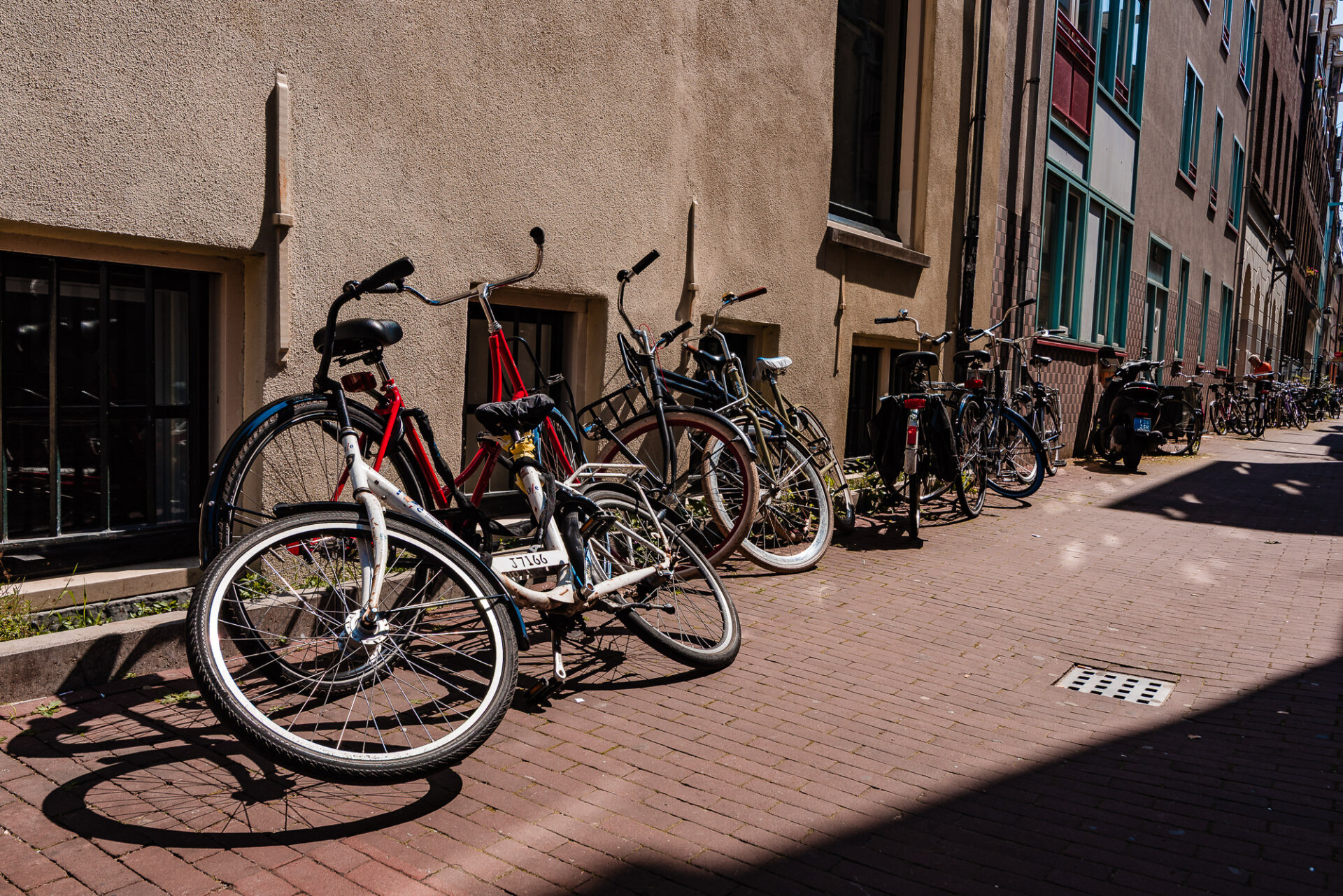 Bicycles parked along a narrow brick-lined street in central Amsterdam