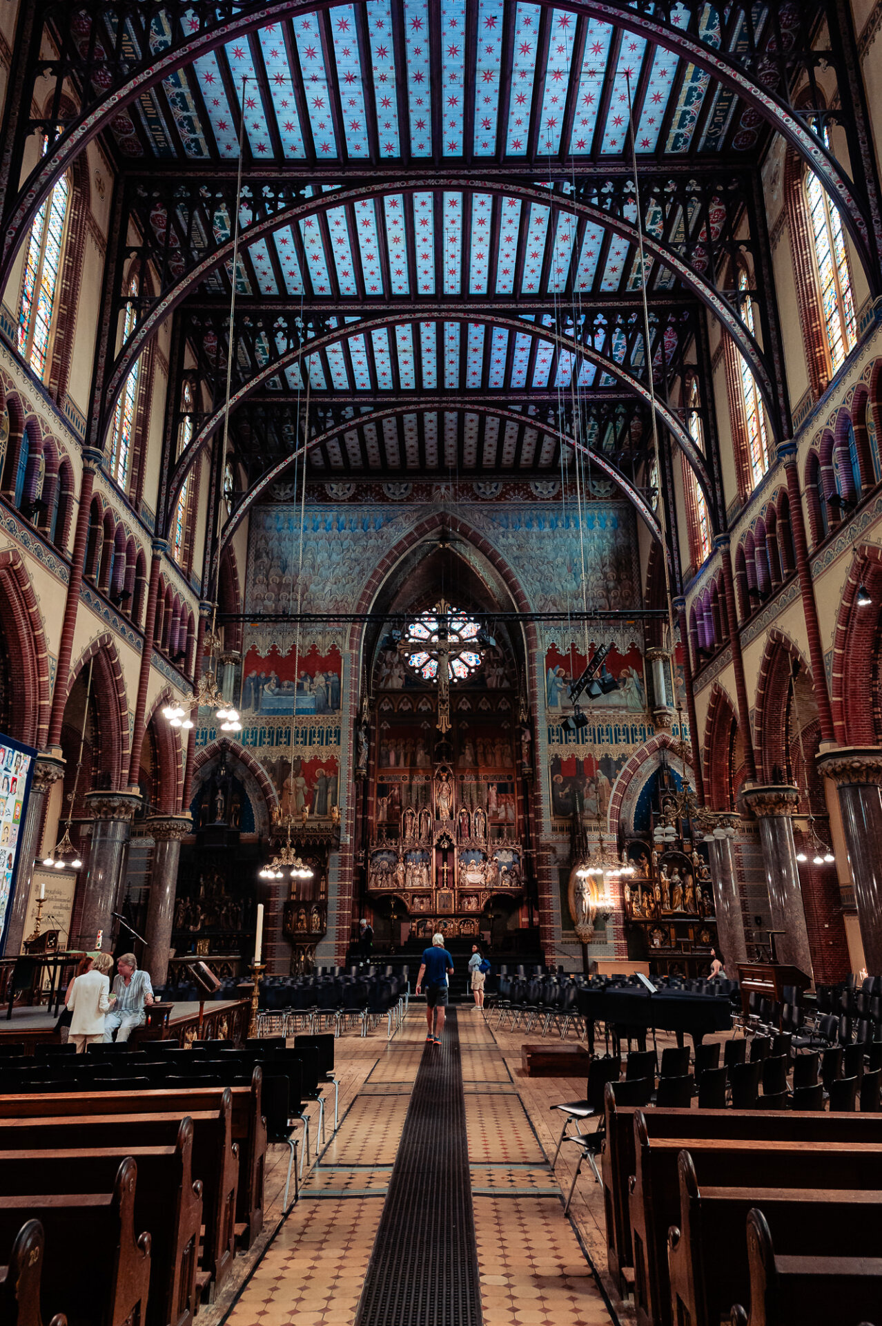 Colourful Gothic church interior featuring vaulted ceilings, religious artwork and an ornate altar